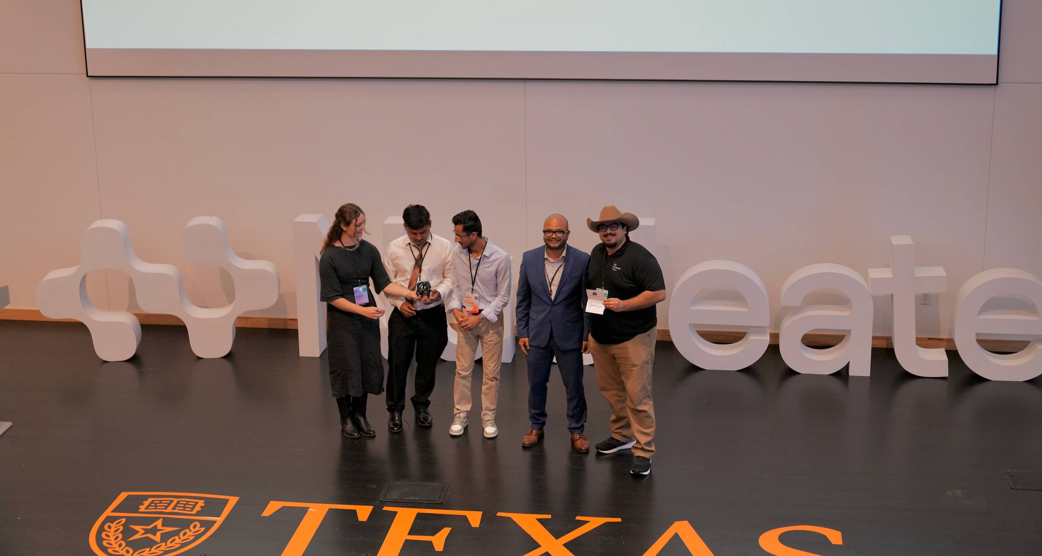 five people on stage receiving award