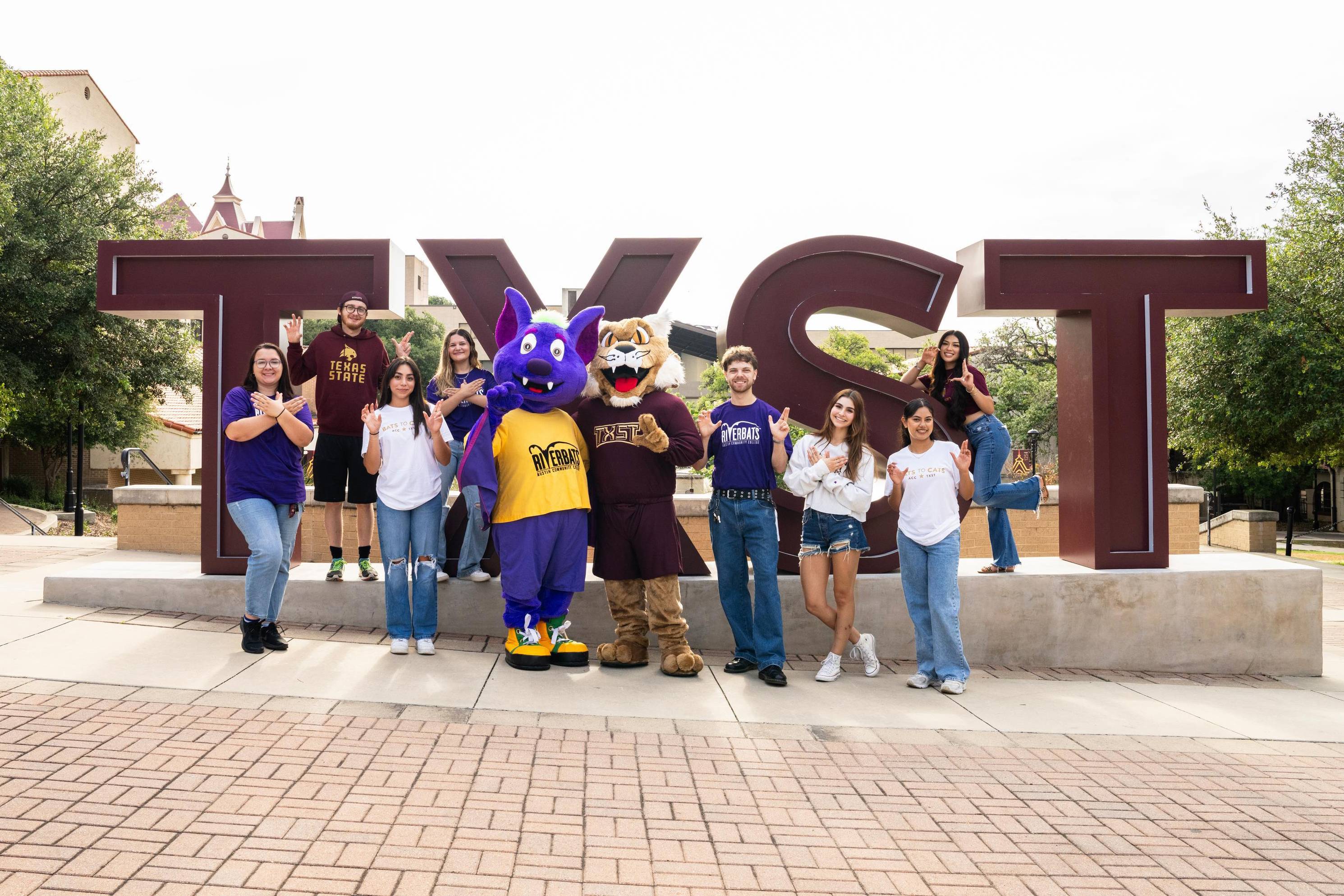 large group of students posing with bat and bobcat mascots