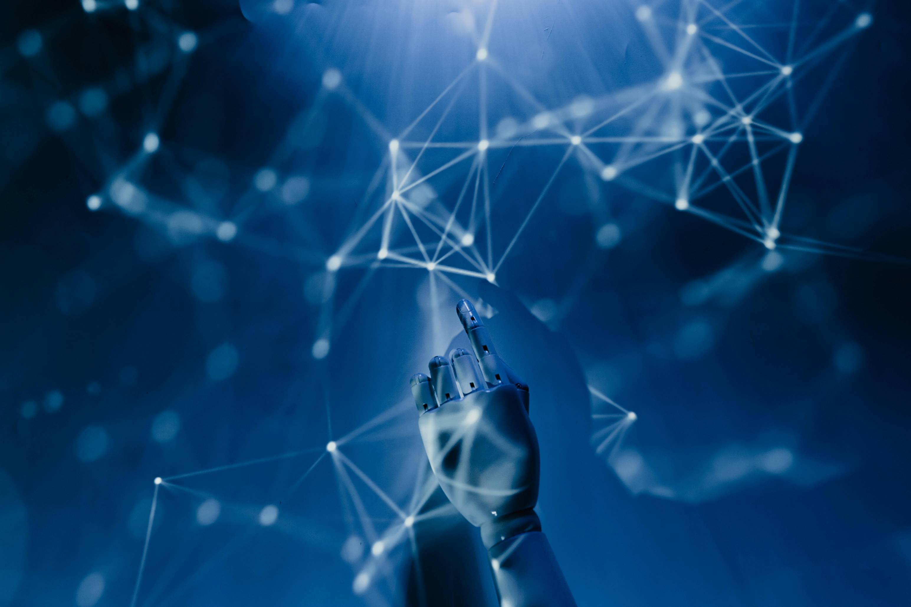 Futuristic image of a robotic hand reaching toward a glowing network of connected points and lines on a blue background. The image represents artificial intelligence, automation, machine learning, digital transformation, data connectivity, and emerging technology for business.