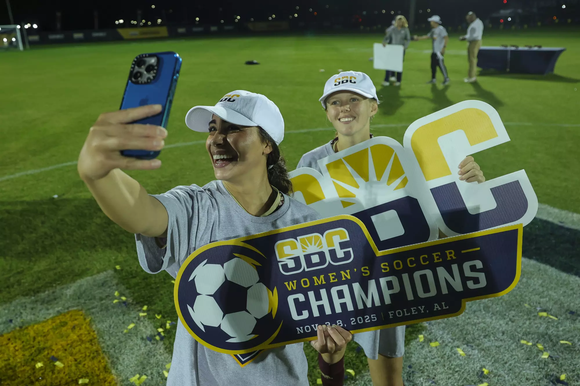 TXST women's soccer team members take selfies with the Sun Belt champions signs.