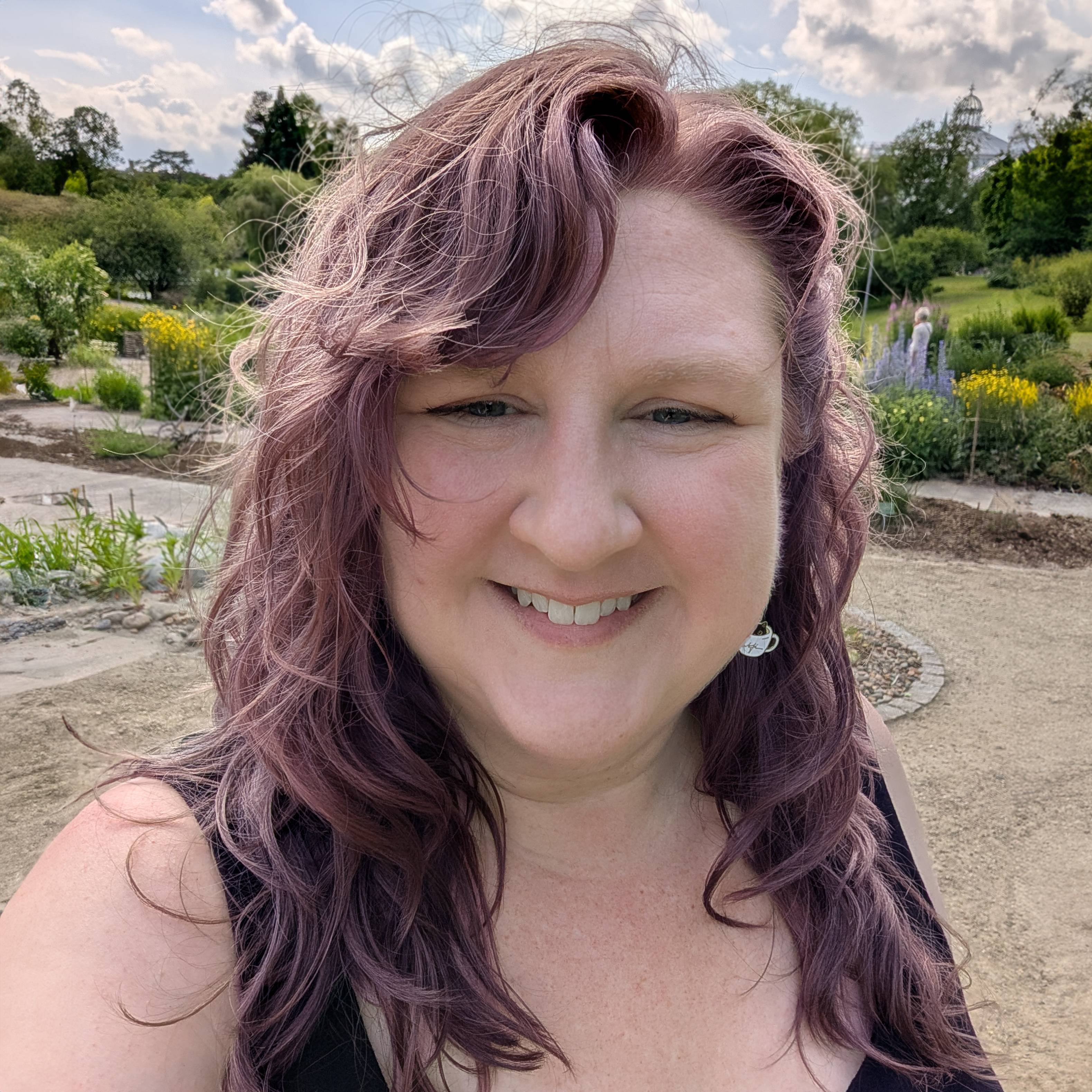 Angela, a white woman with wavy purple hair, at a park.