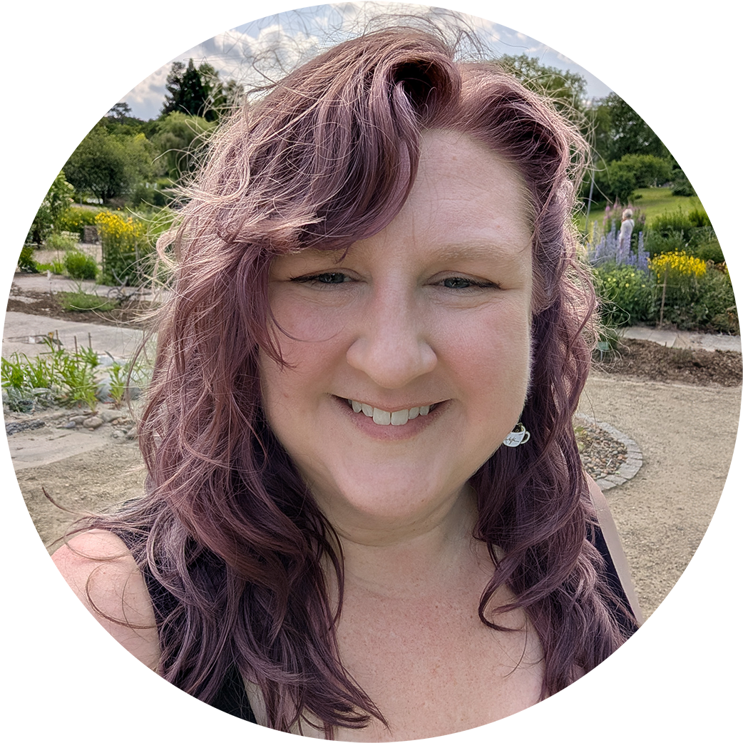 Headshot of a white woman with purple hair.
