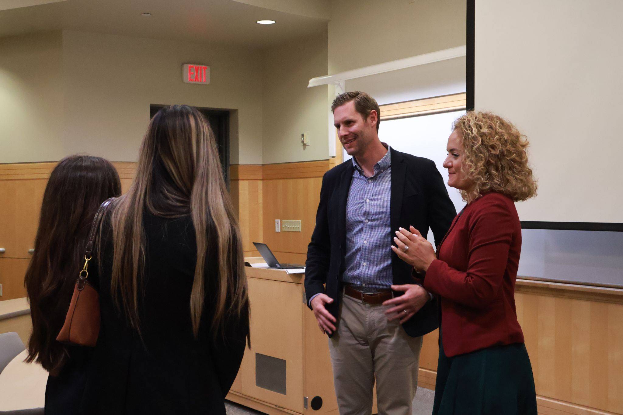 two students speaking with two business professionals