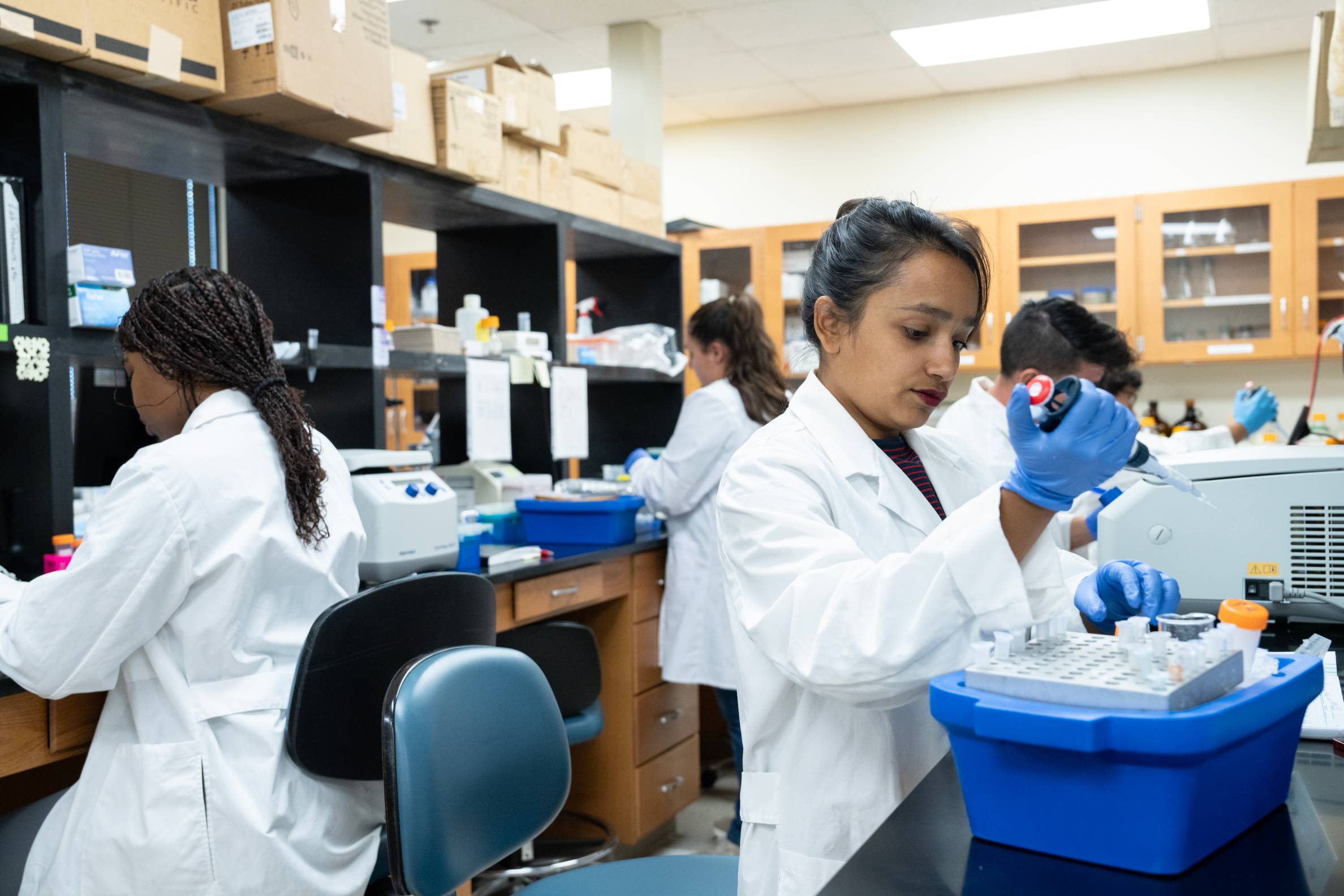 People in lab coats conduct a scientific experiment in a laboratory. 