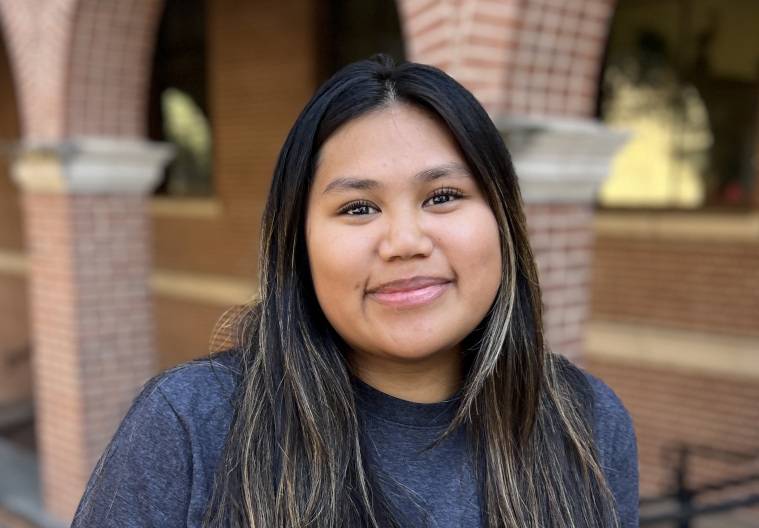 Photo of Jazmin Rodriguez standing in front of arches, wearing a Bobcat IDEA T-shirt.