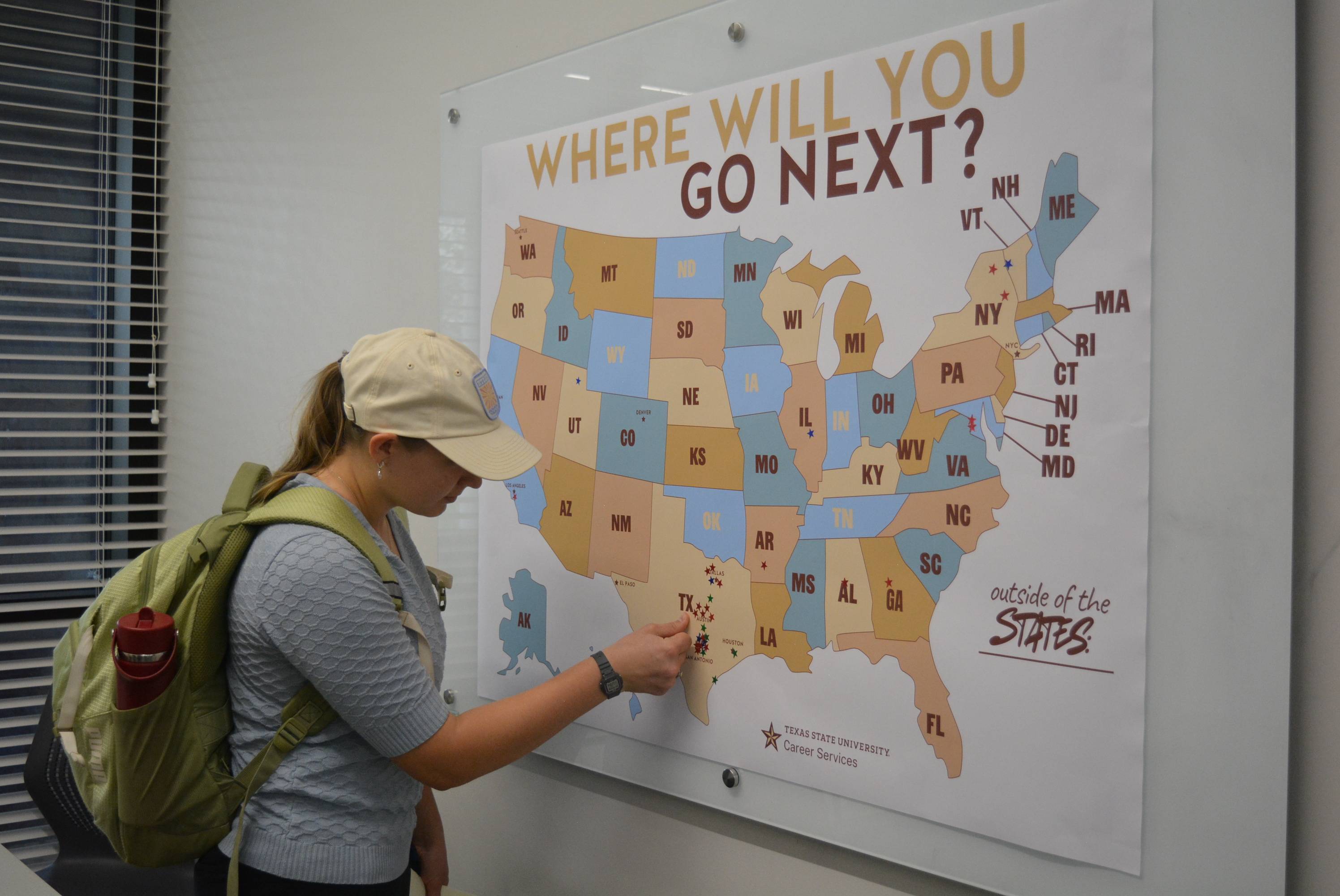 woman placing sticker on state of texas on U.S. map