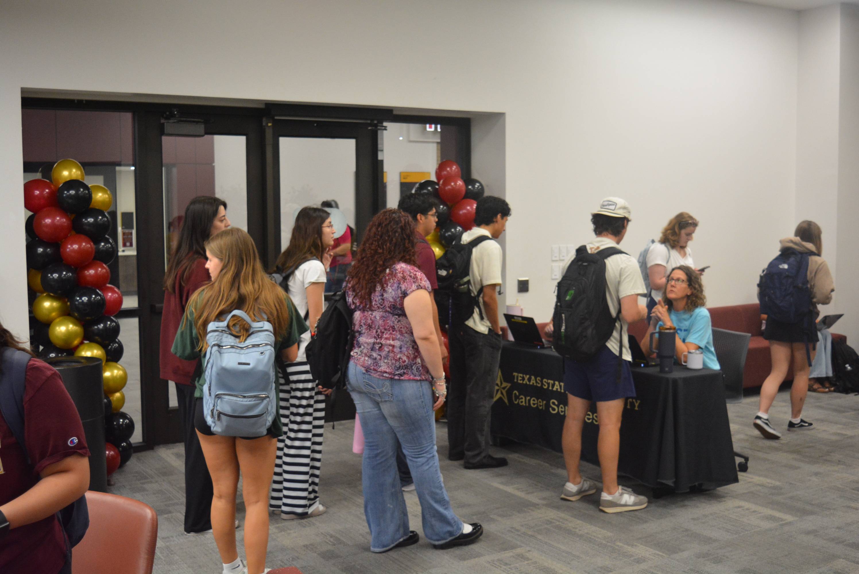 people waiting in line to check in at career services table
