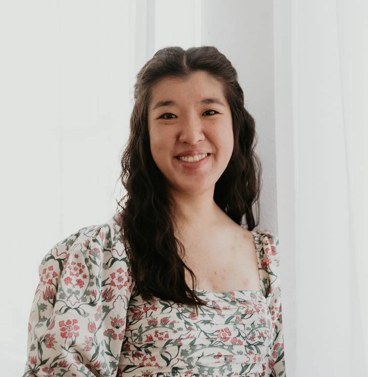 young woman with dark hair smiling at camera