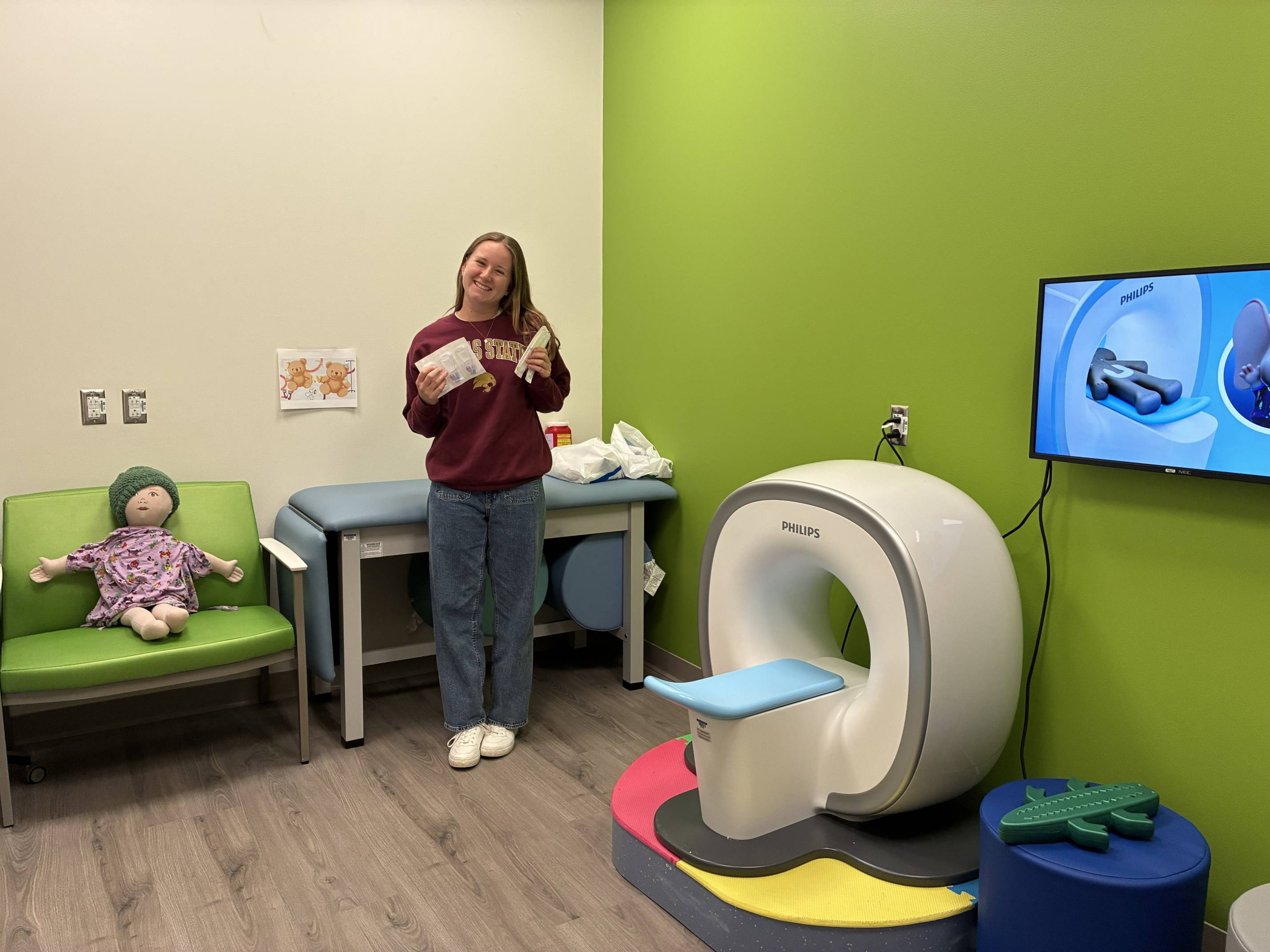 woman holding up medical supplies in children's medical suite