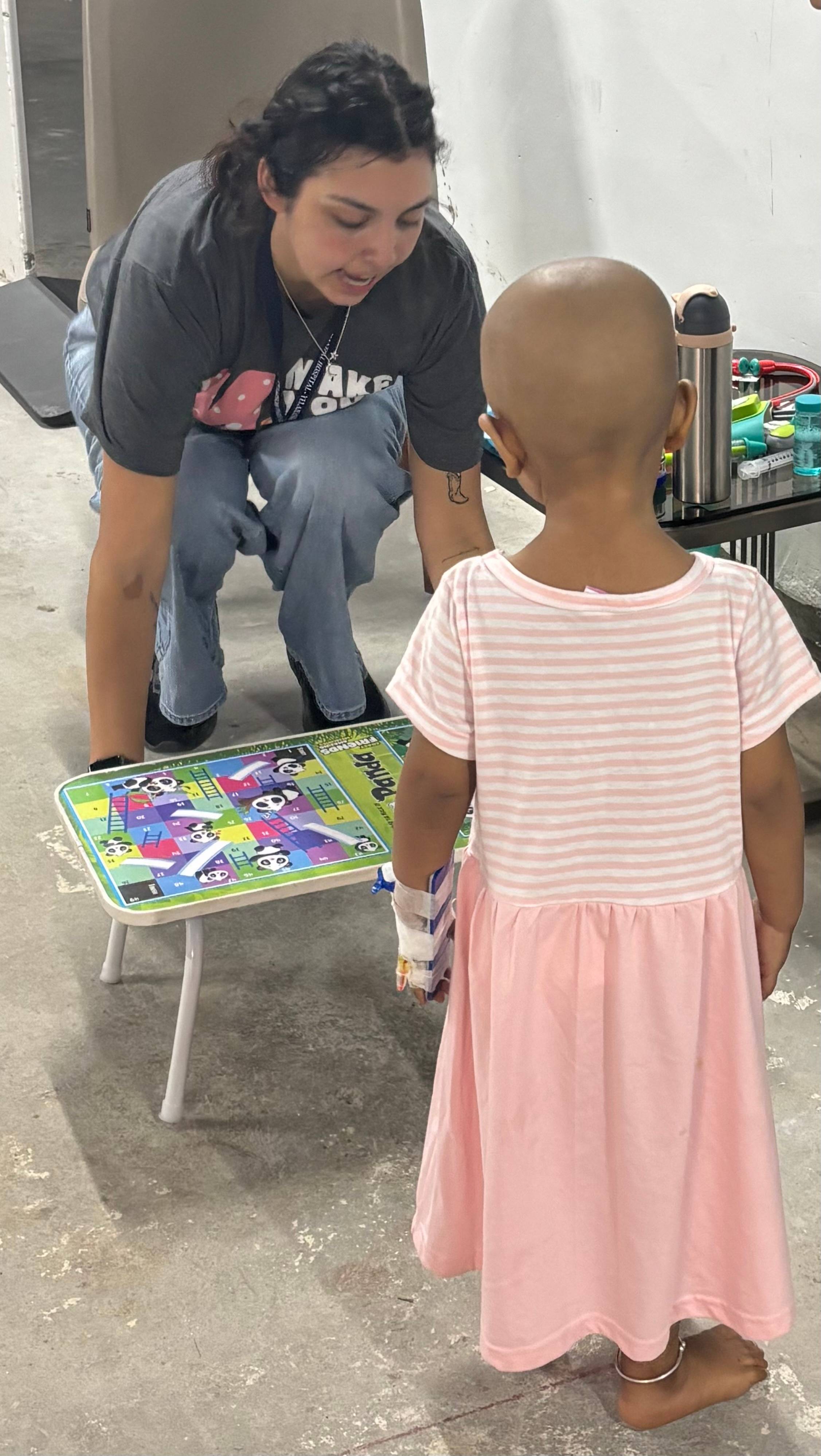 woman helping sick child with small table