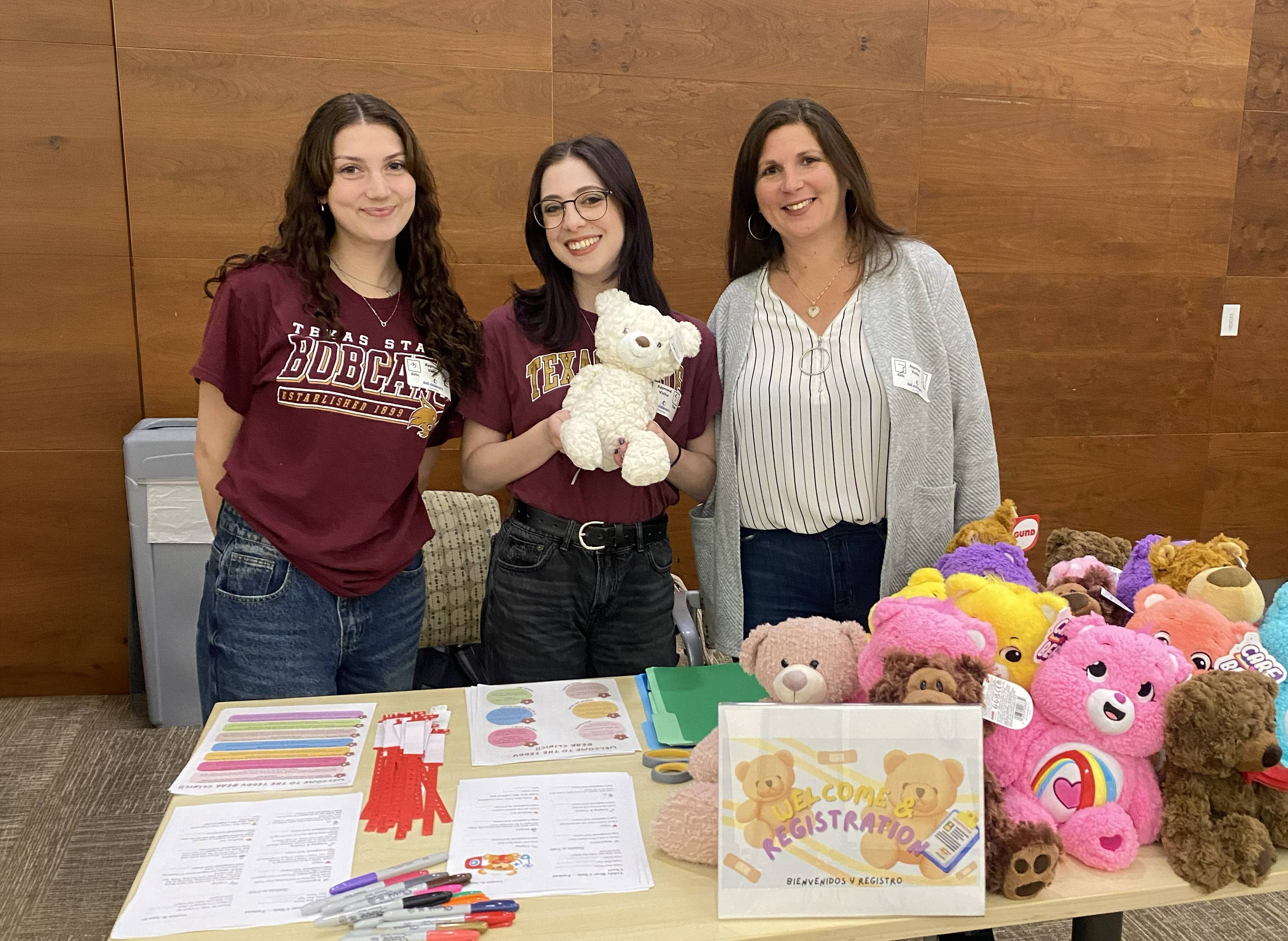 Students and faculty pose for a photo at a tabling event.