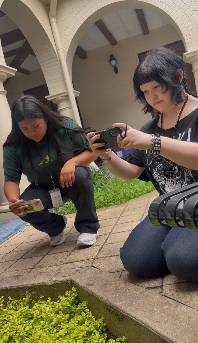 two young woman recording something with their phones