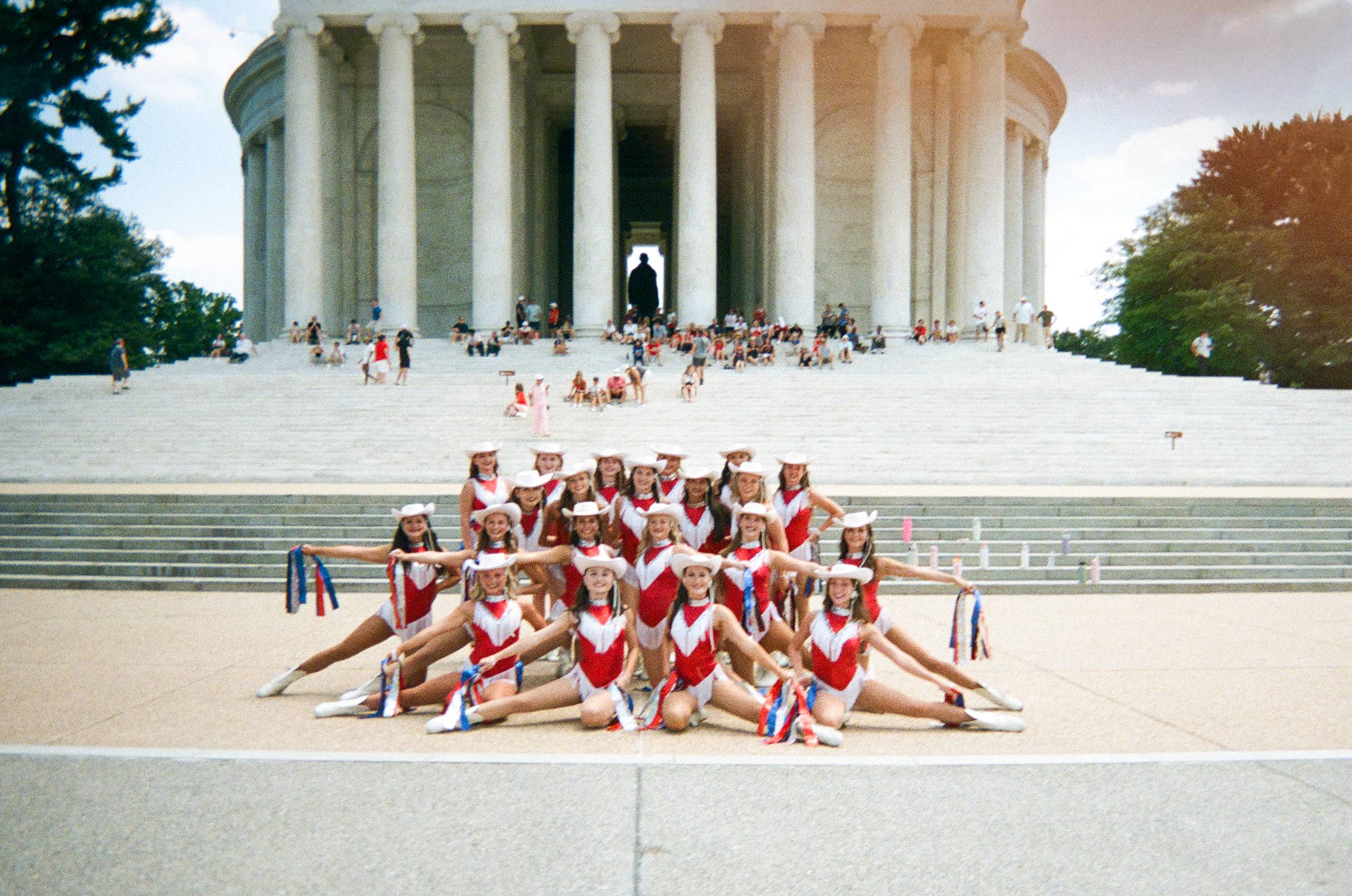 the strutters pose in front of a monument 