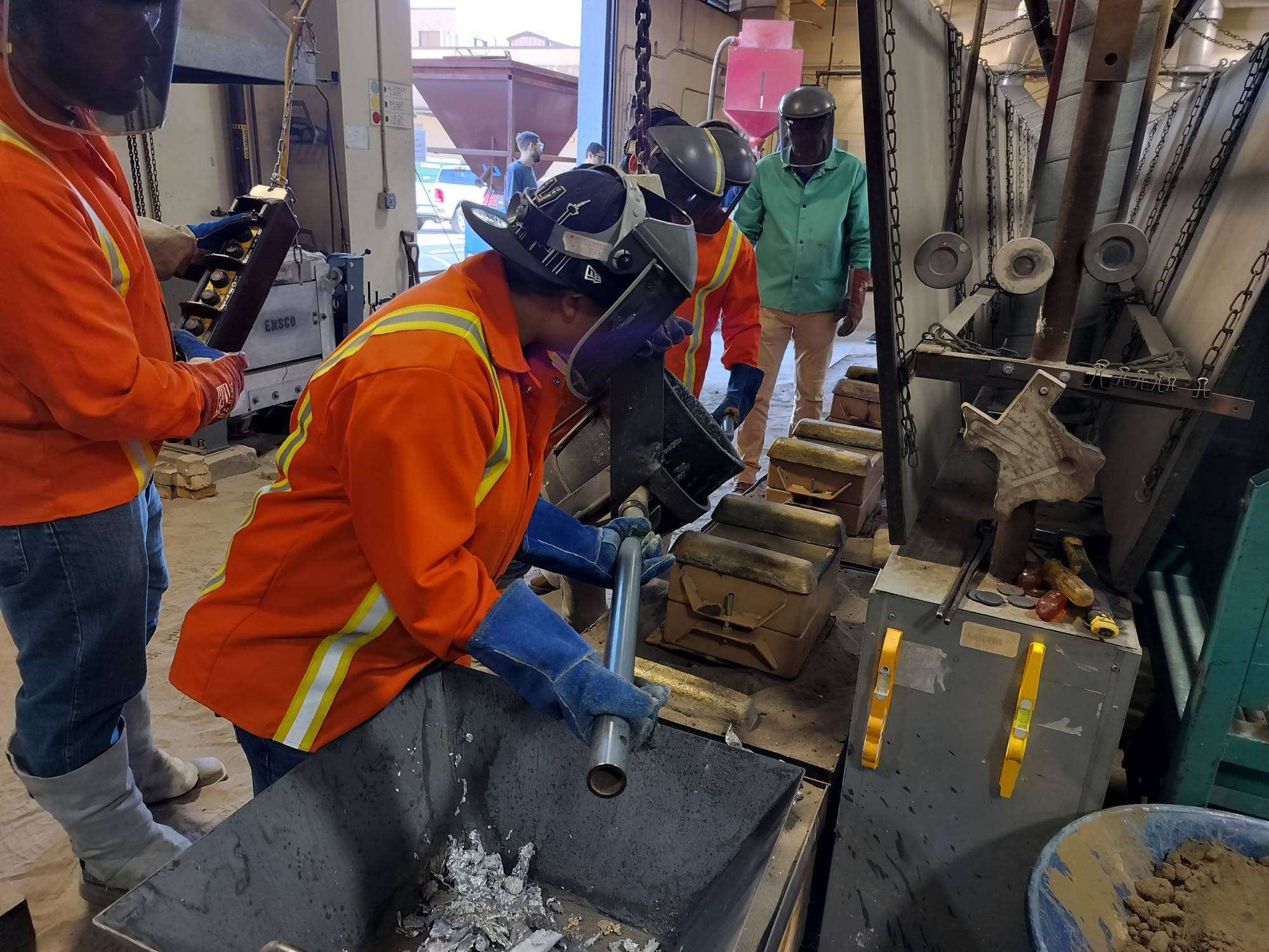 student holding molten getting ready to pour