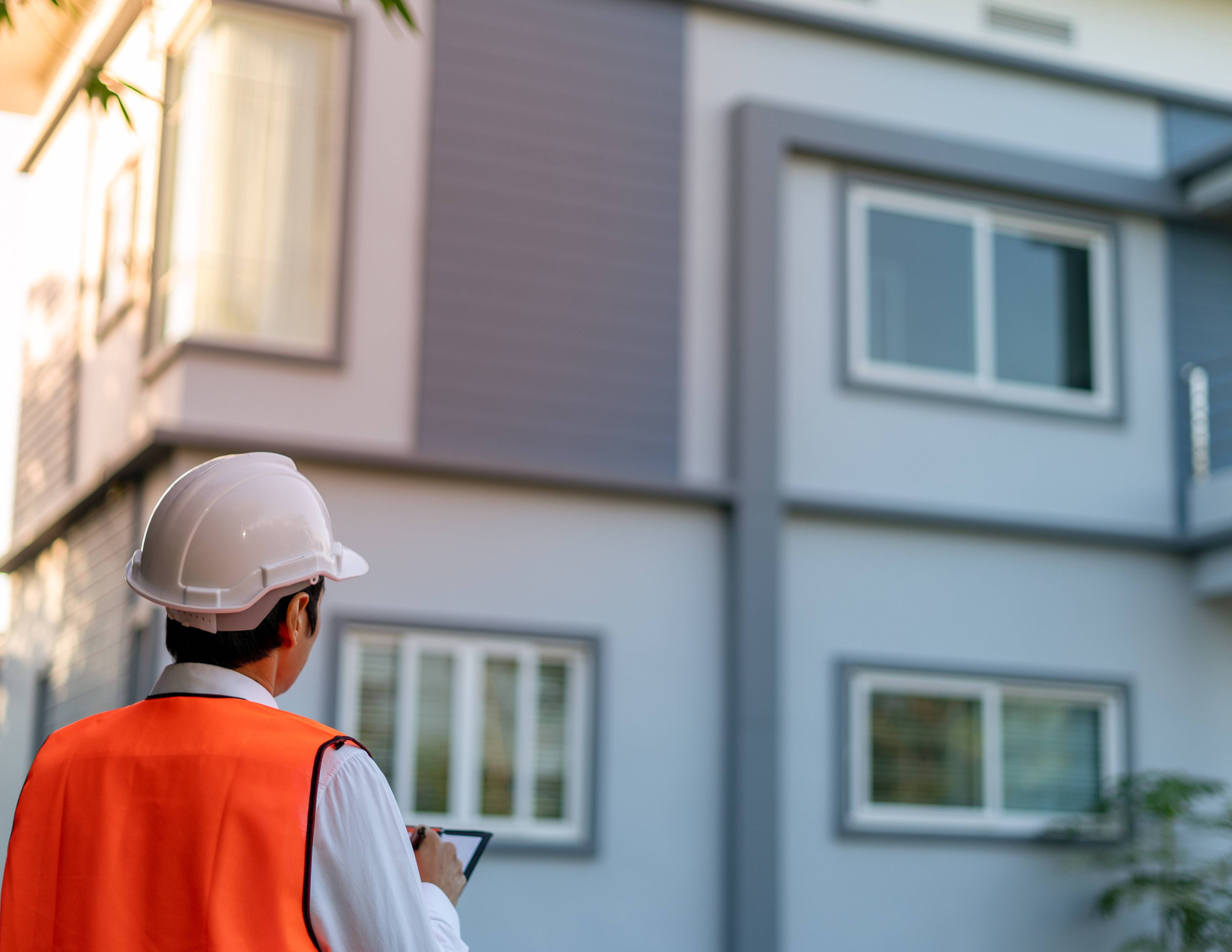 a man is safety vest inspects a home