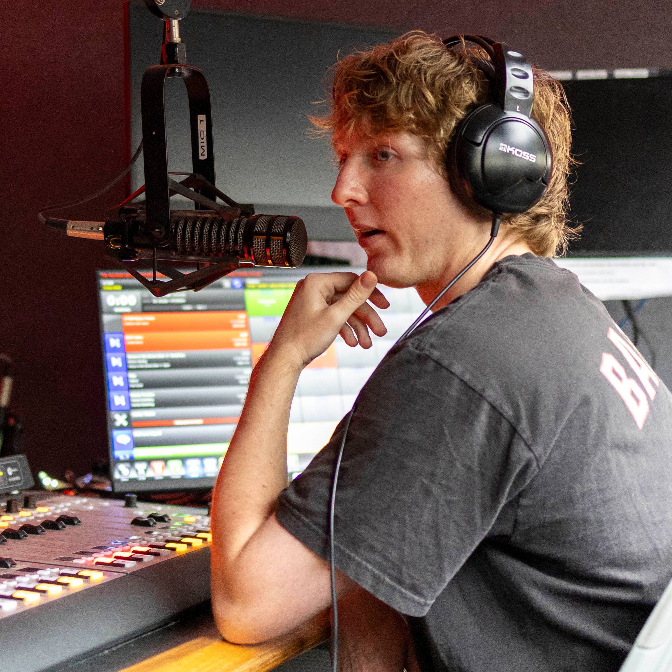 Student speaking into a mic during a radio broadcast.