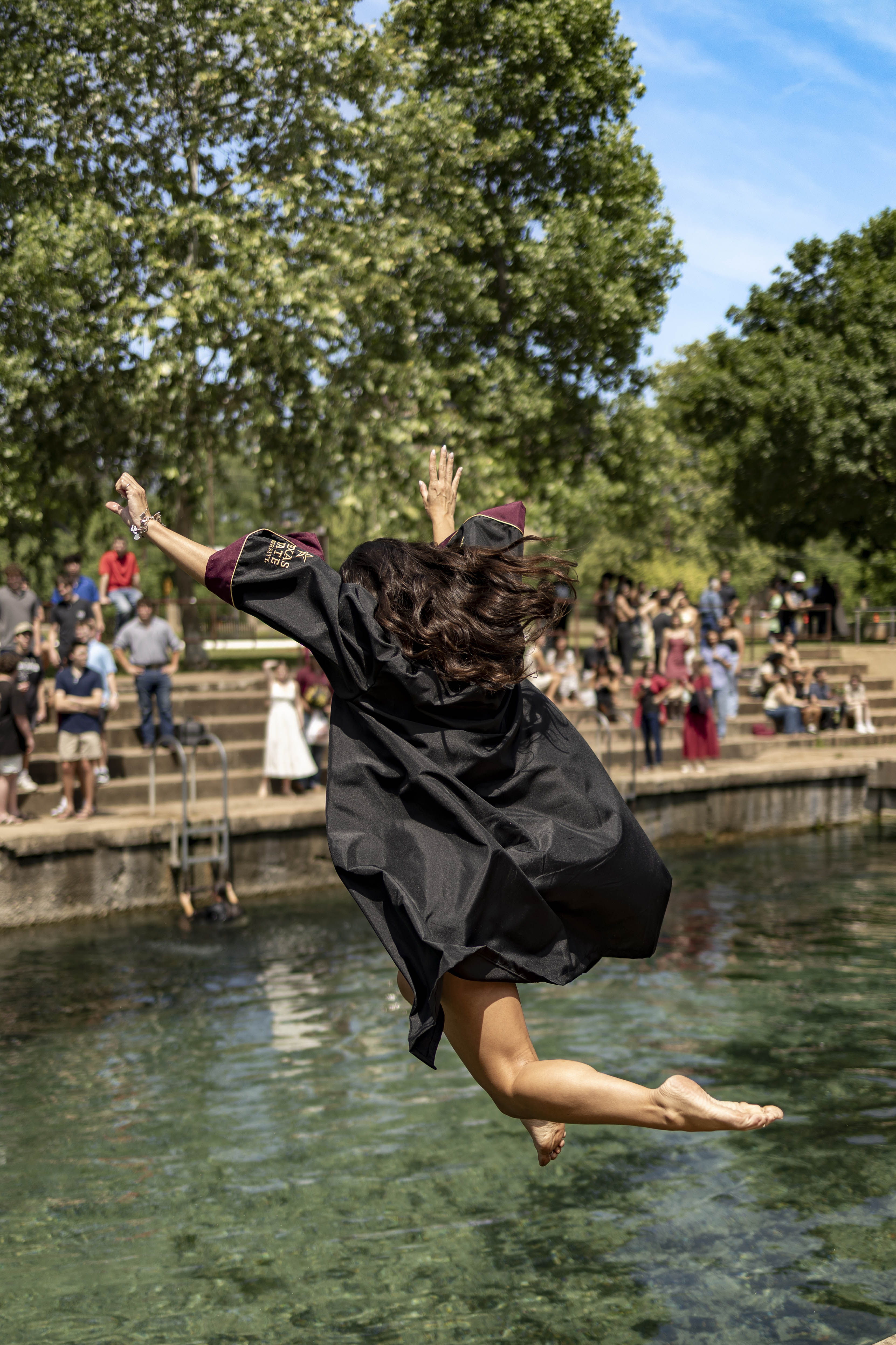 girl in grad gown jumps in to the river