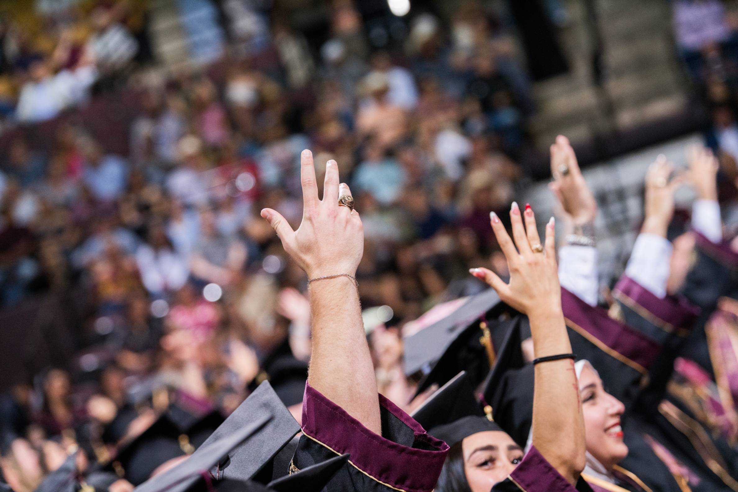 hands held up wearing texas state class rings