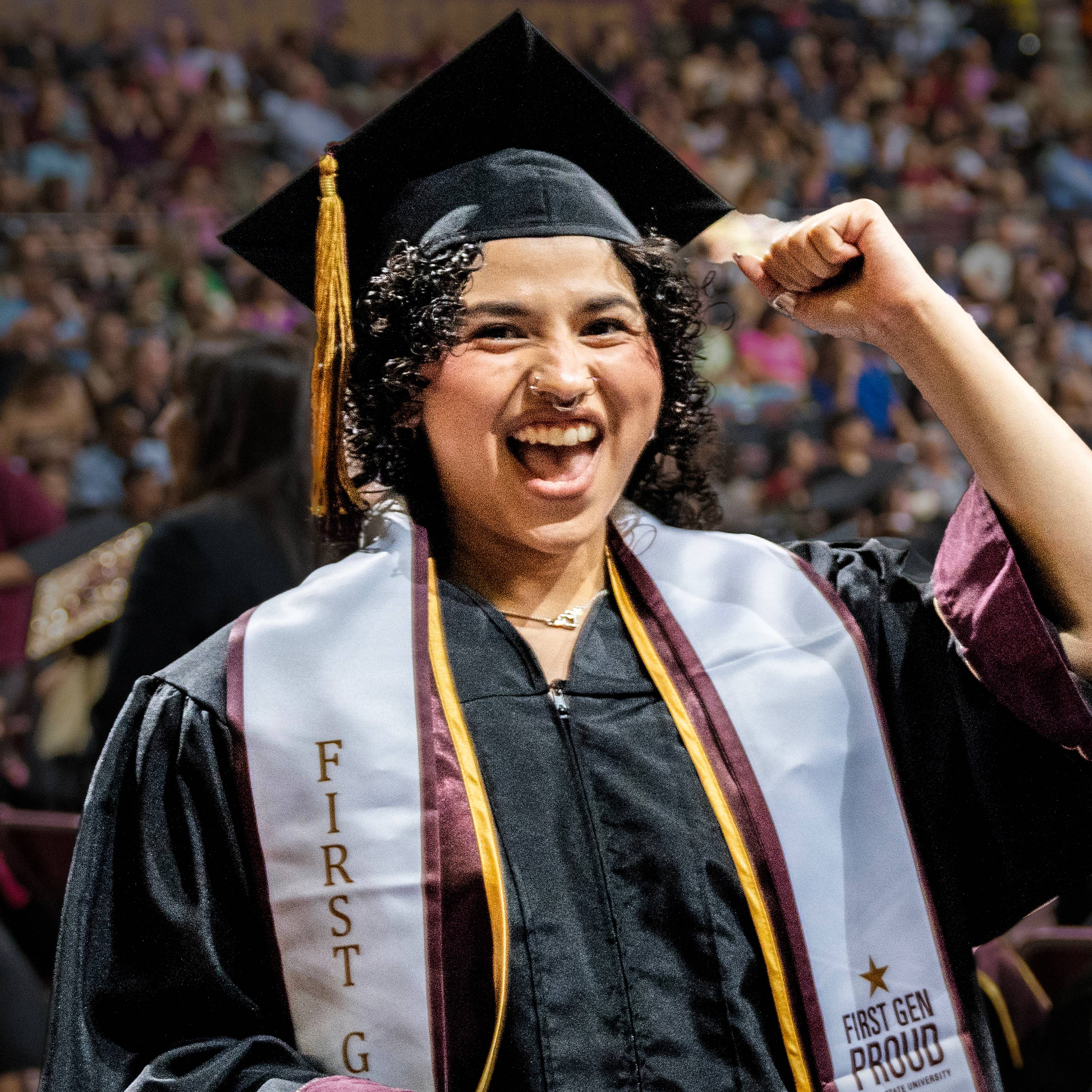 Student fist pumps as they walk to the stage at graduation.