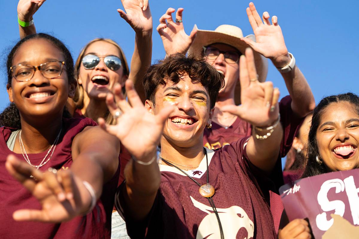 Students cheer at a Texas State football game.