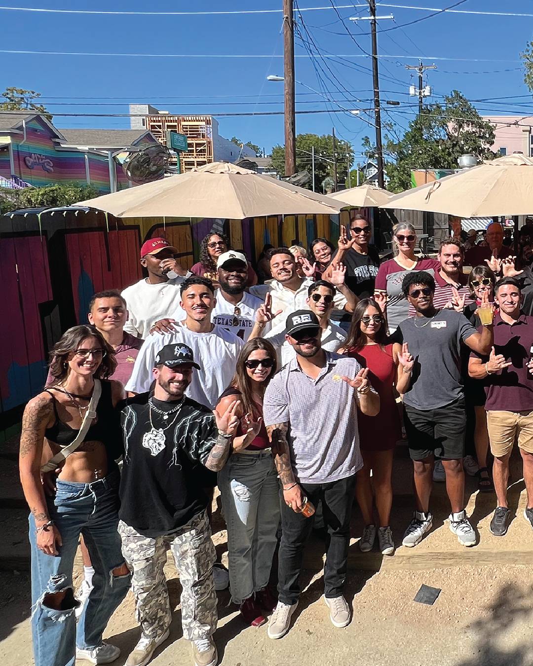 Group of Texas State fans at a watch party at an outdoor restaurant