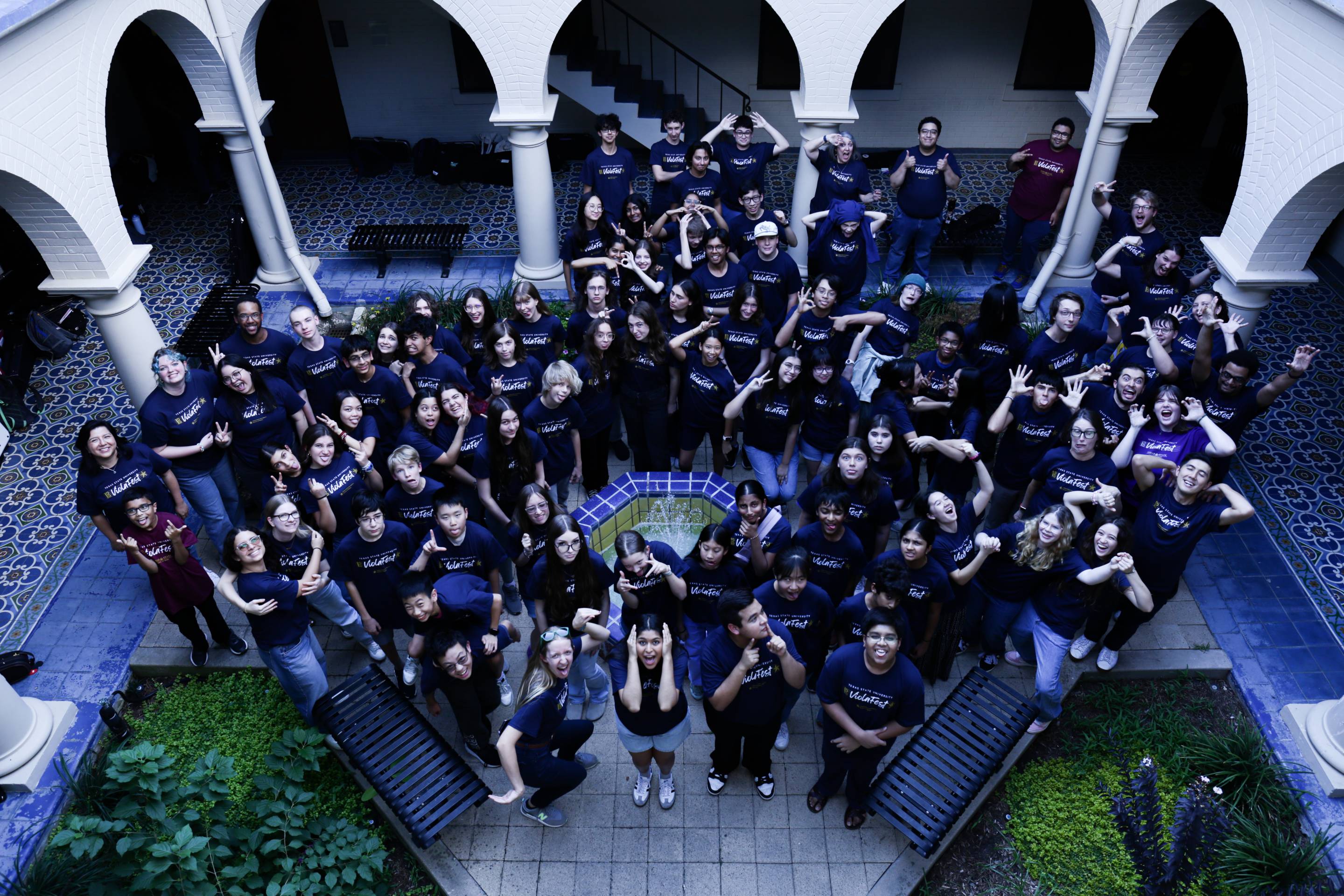 A large group of smiling Texas State ViolaFest participants wearing purple t-shirts.