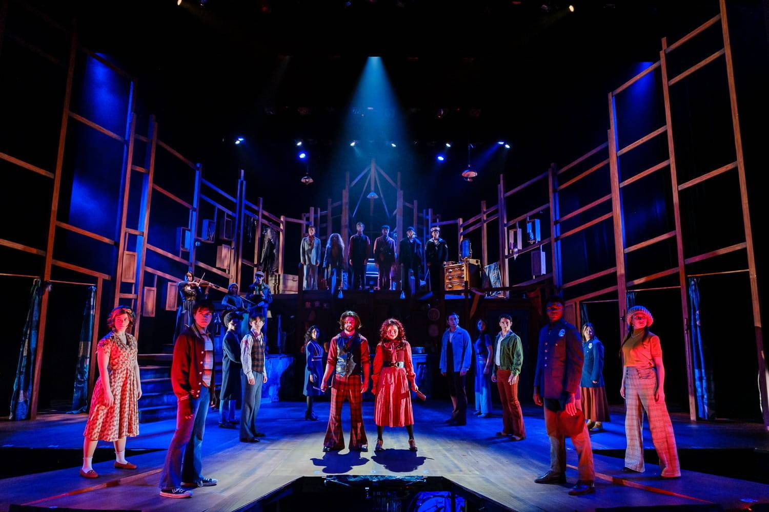 actors performing Sweeney Todd on stage with dramatic red and blue lighting