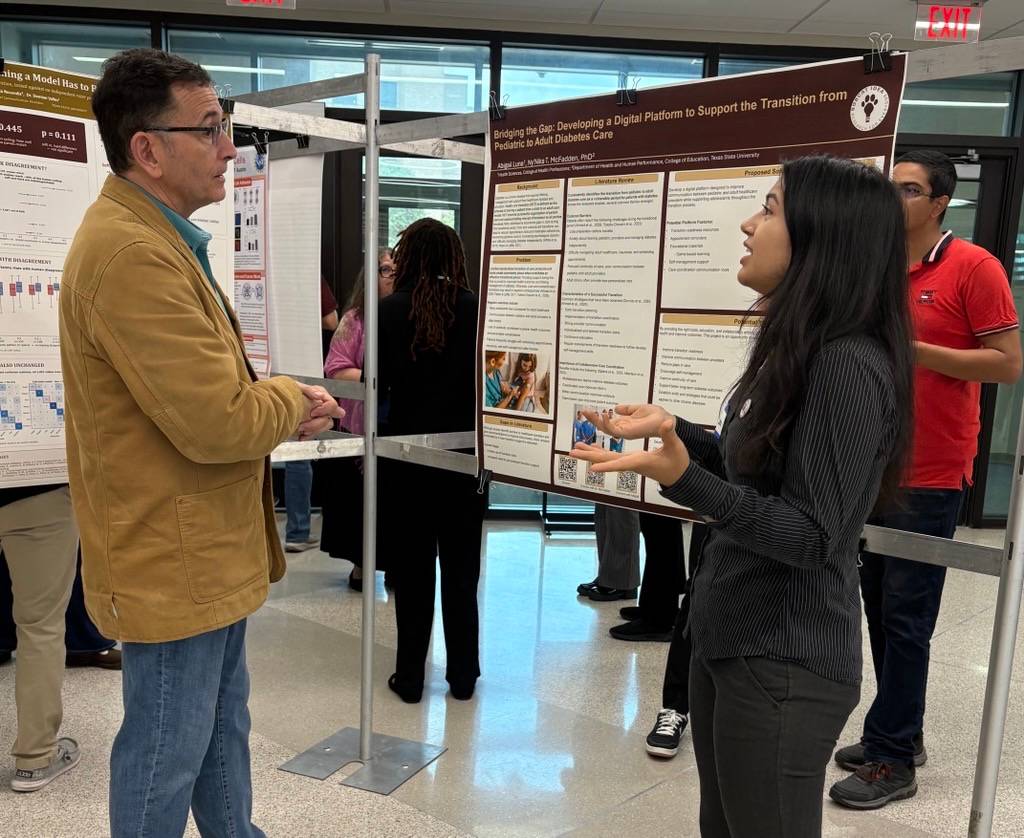 IDEA Center student standing in front of her research poster at a poster presentation. The poster shows images and descriptions from her research project. 