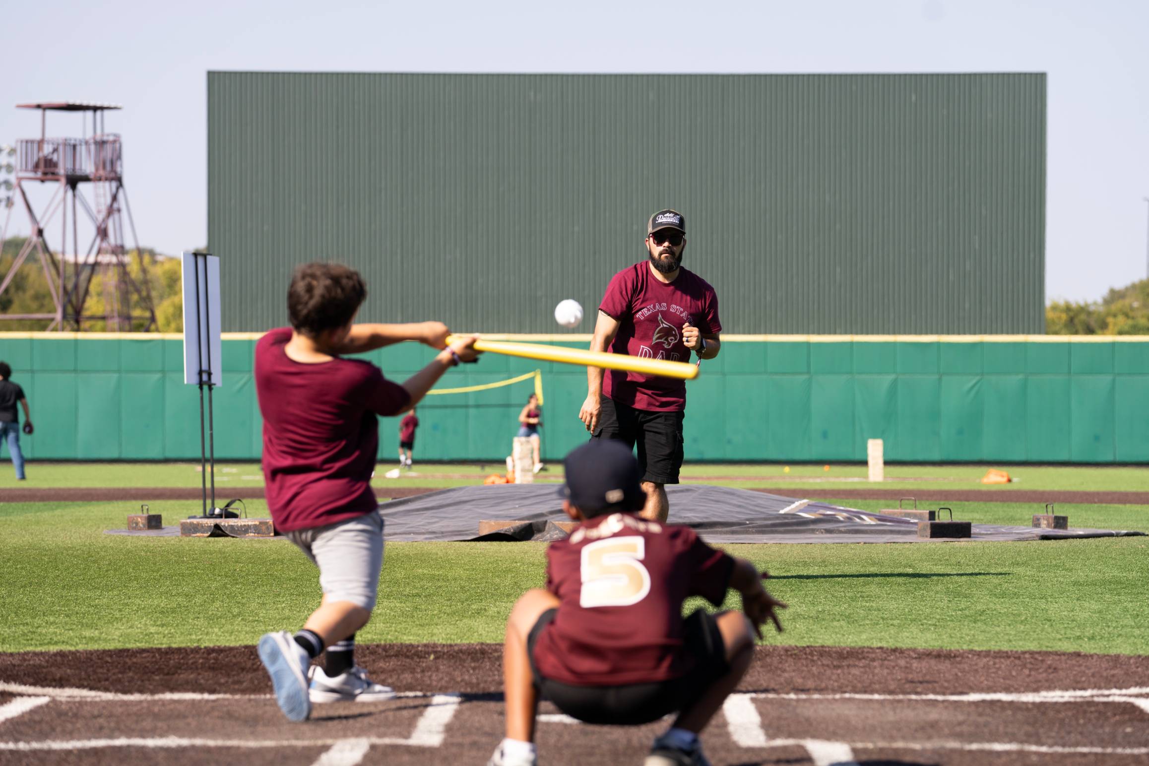 Dad throwing baseball at family weekend to sons 