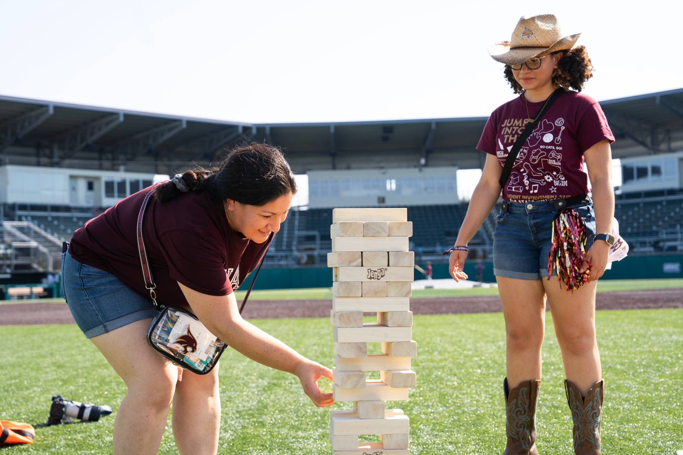 mother and daugher playing jenga on a baseball field