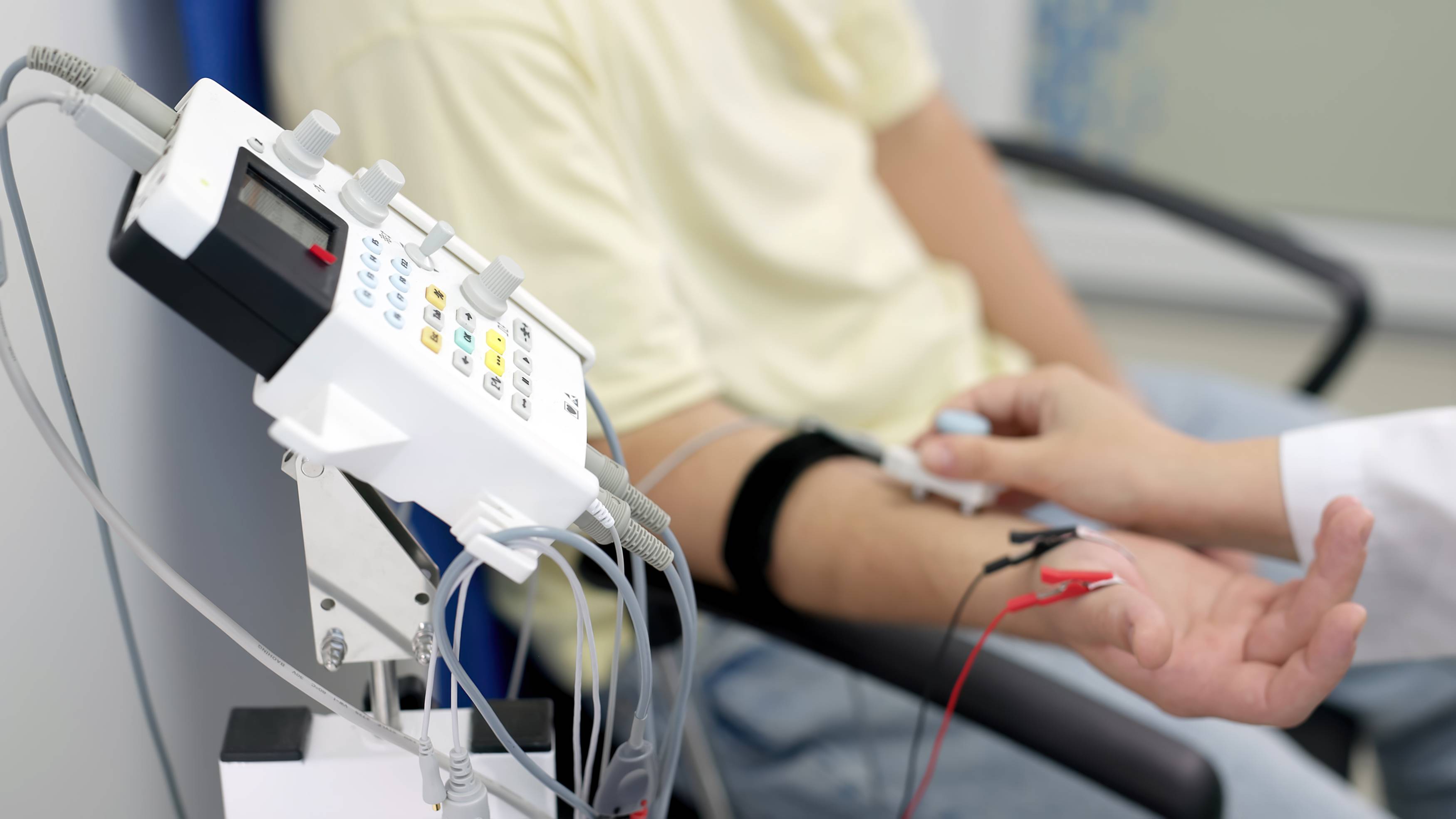 Patient sits in a chair attached to medical devices reading signals