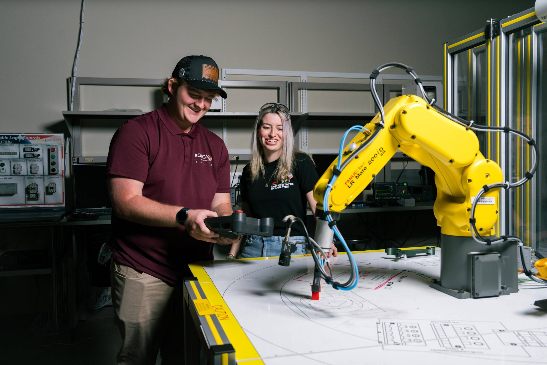 man and woman playing with yellow robotic arm