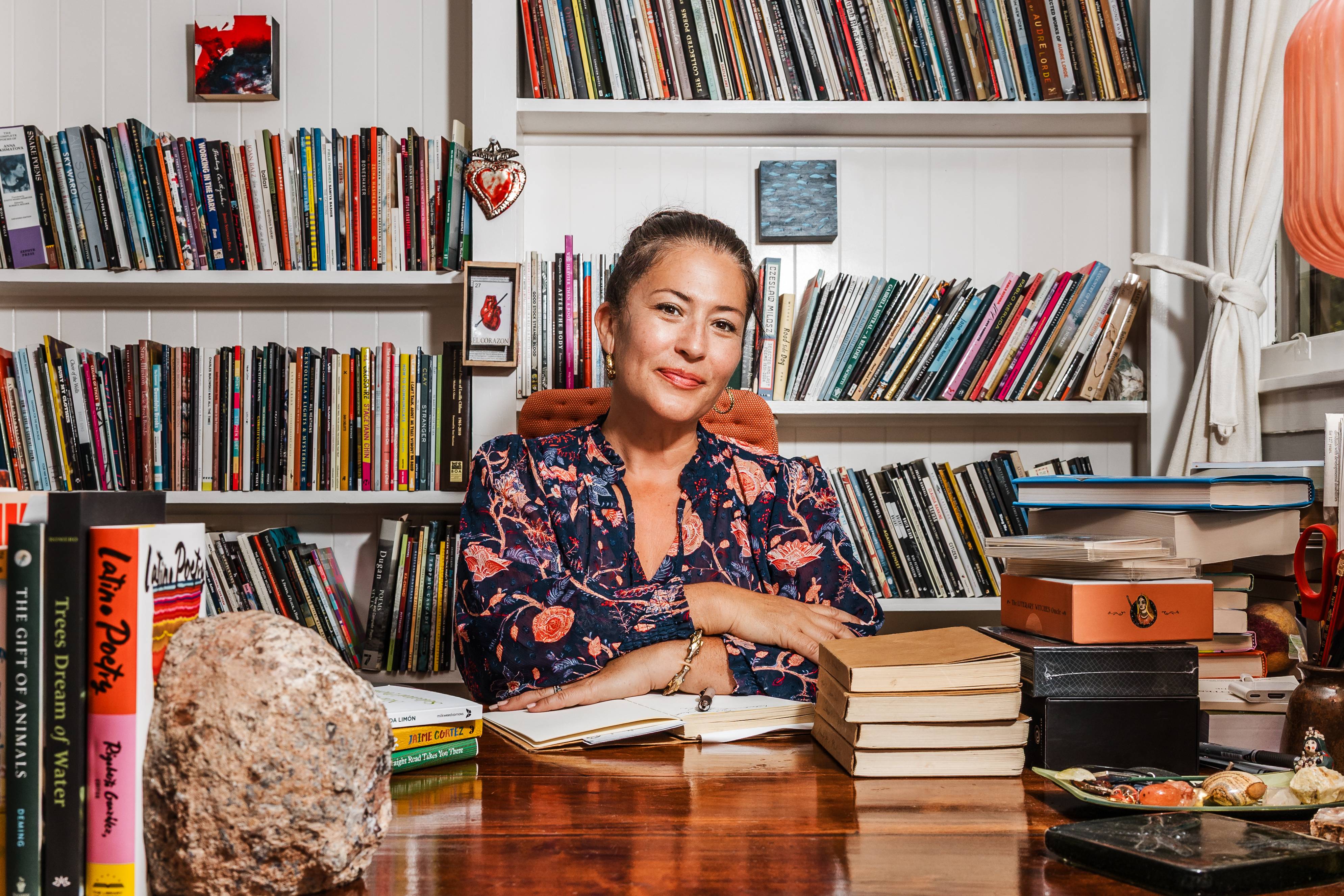 ada limon sitting at a wooden desk surrounded by books