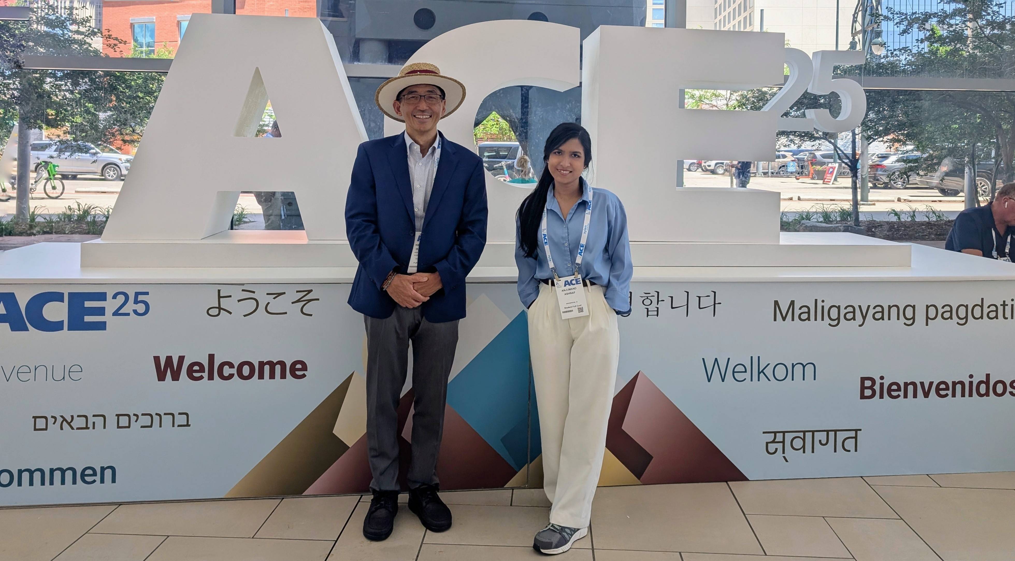 man in large straw hat and woman standing next to large ACE sign