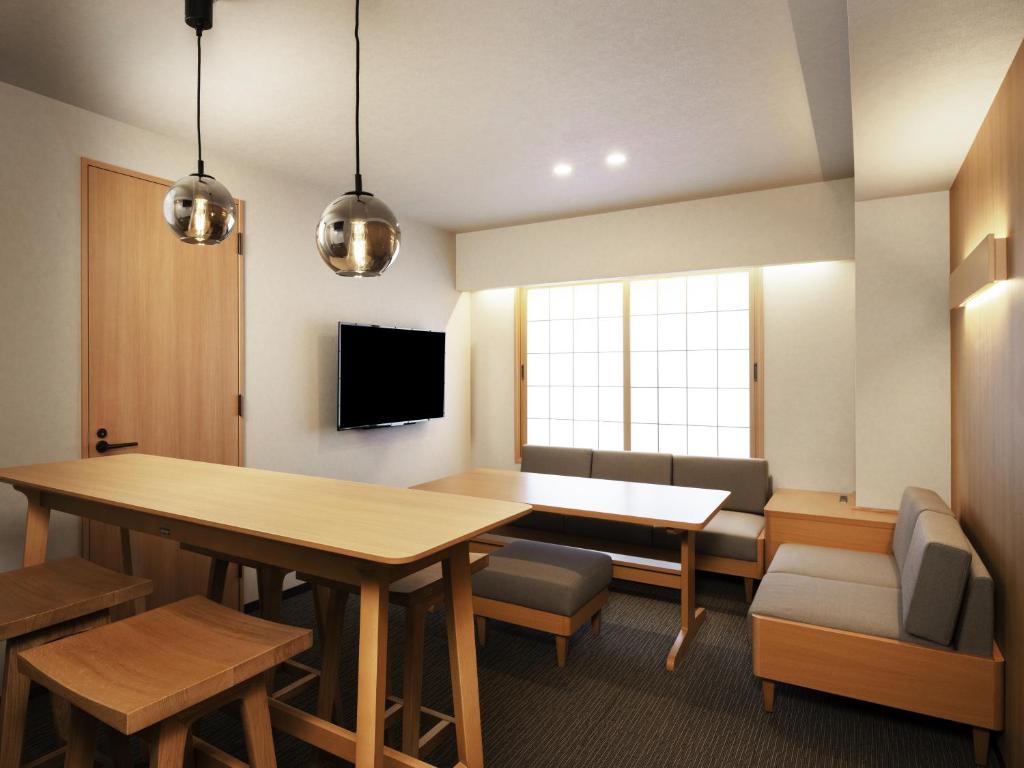 interior of hotel living room with dining table, small couch, and TV