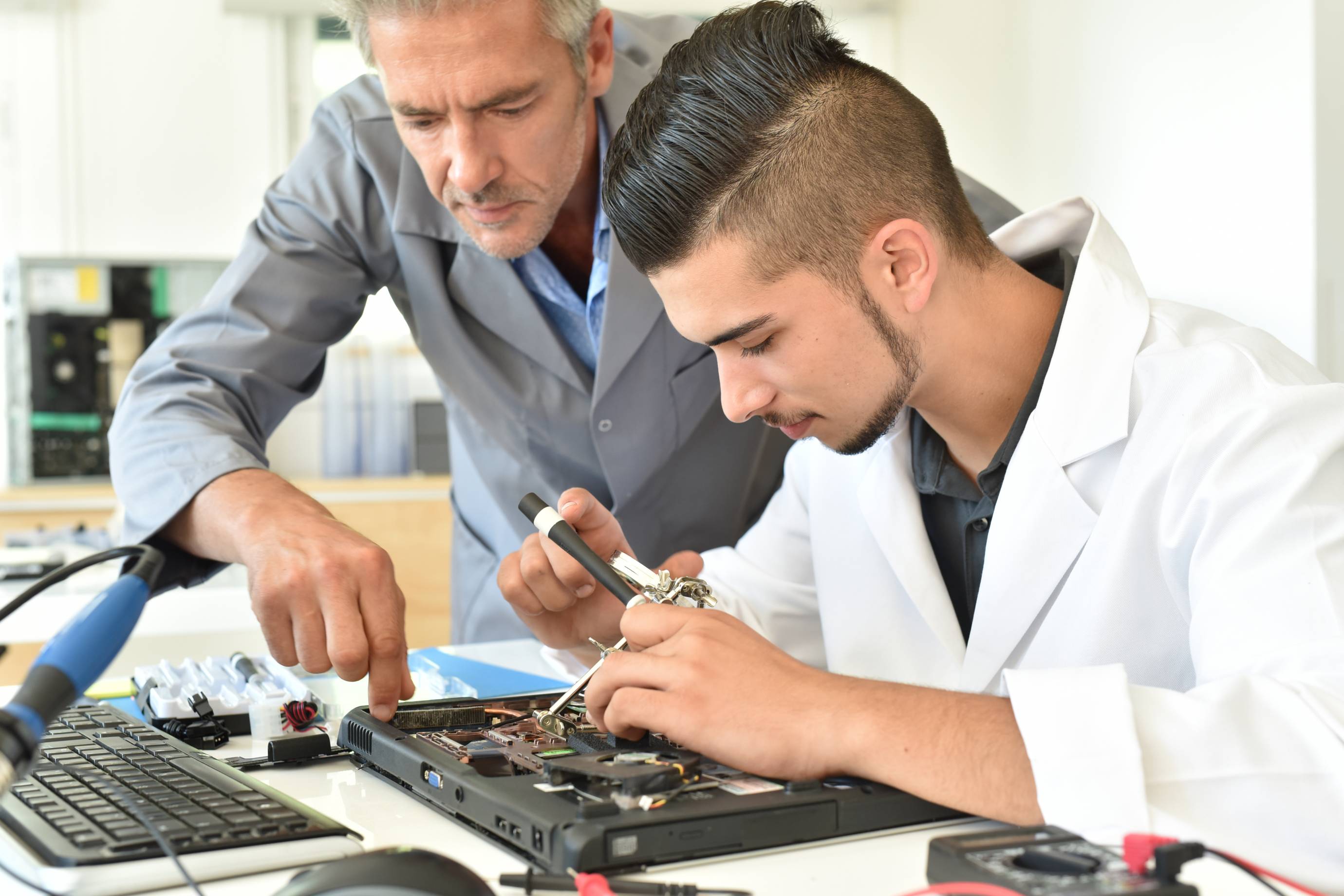 male professor helping male electrical engineering student