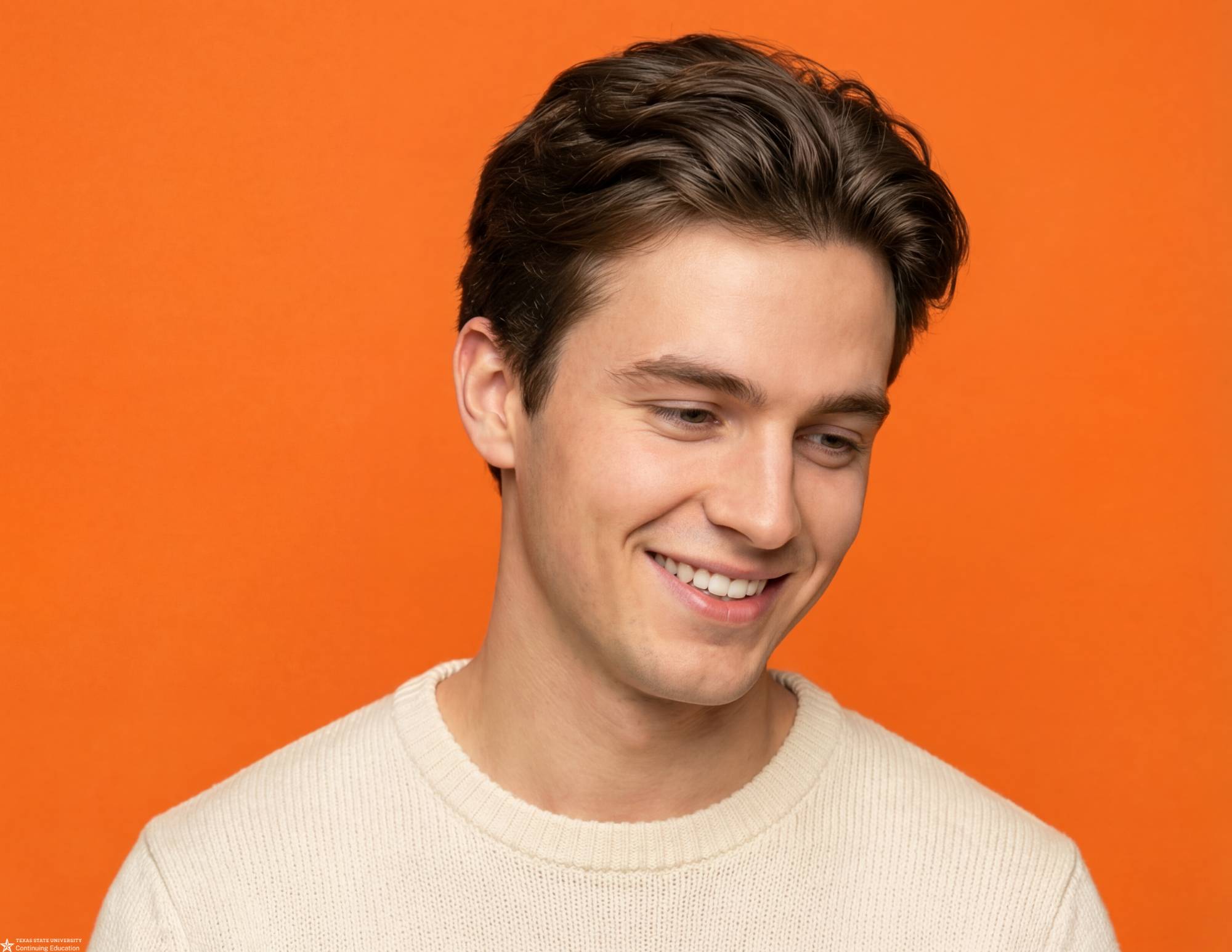 a man in a beige sweater with orange background