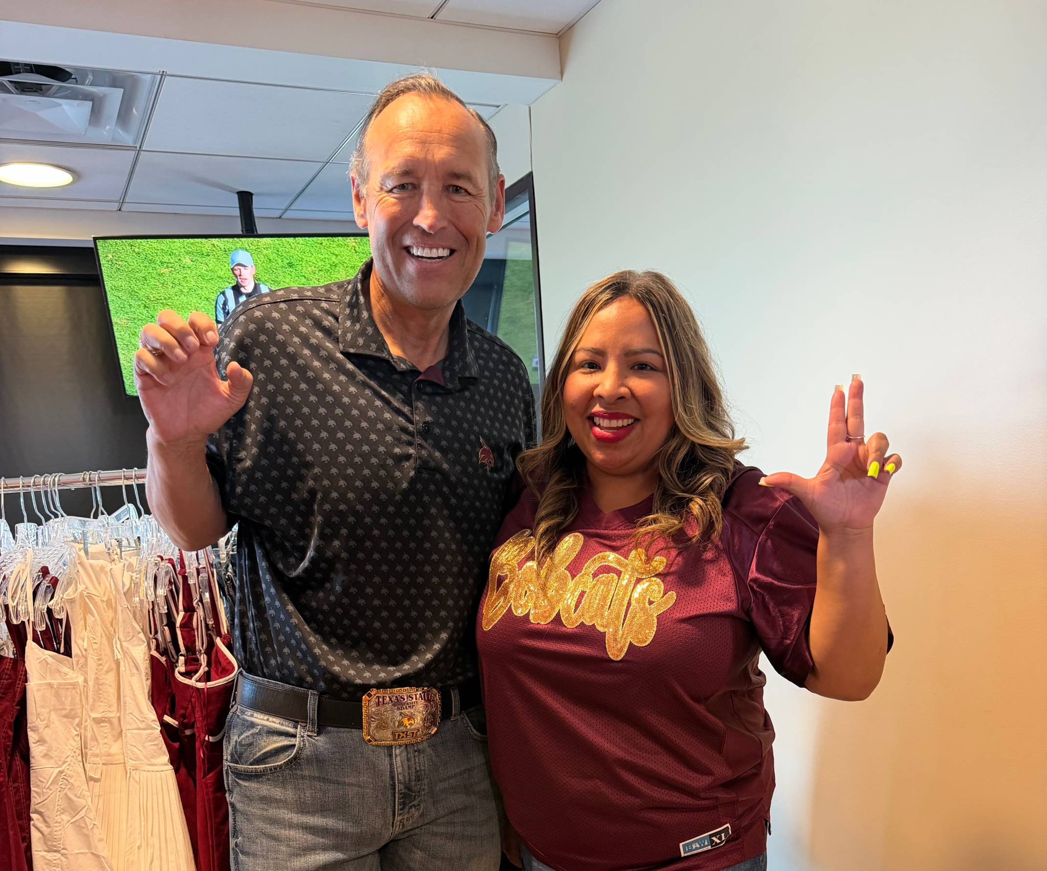 President Damphousse and Kristan Machado pose with txst hand signs