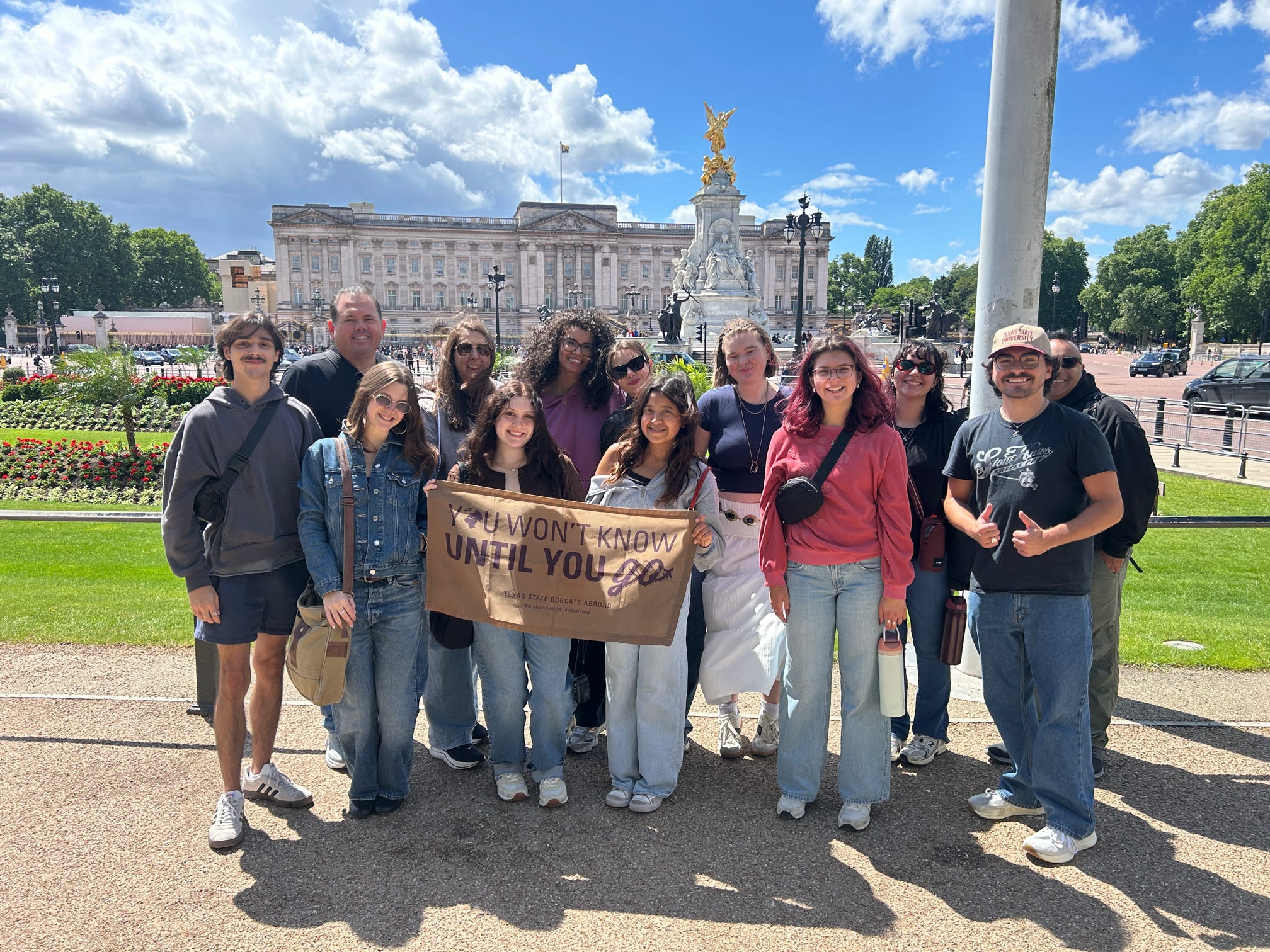 a group of Texas State students and staff members standing in front of the Buckingham Palace - London, United KIngdom