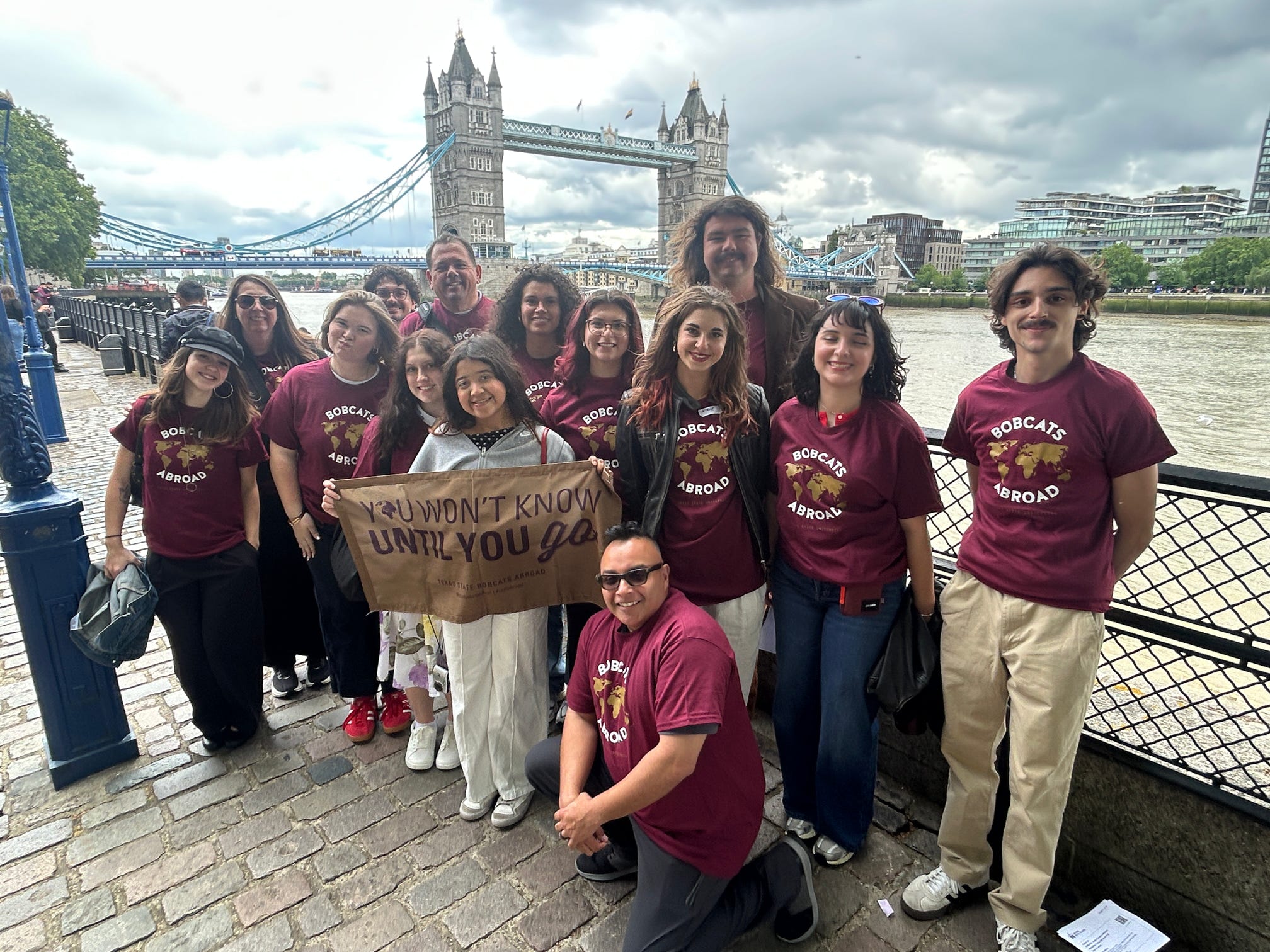 a group of texas state students and staff members standing in front of the London Tower Bridge