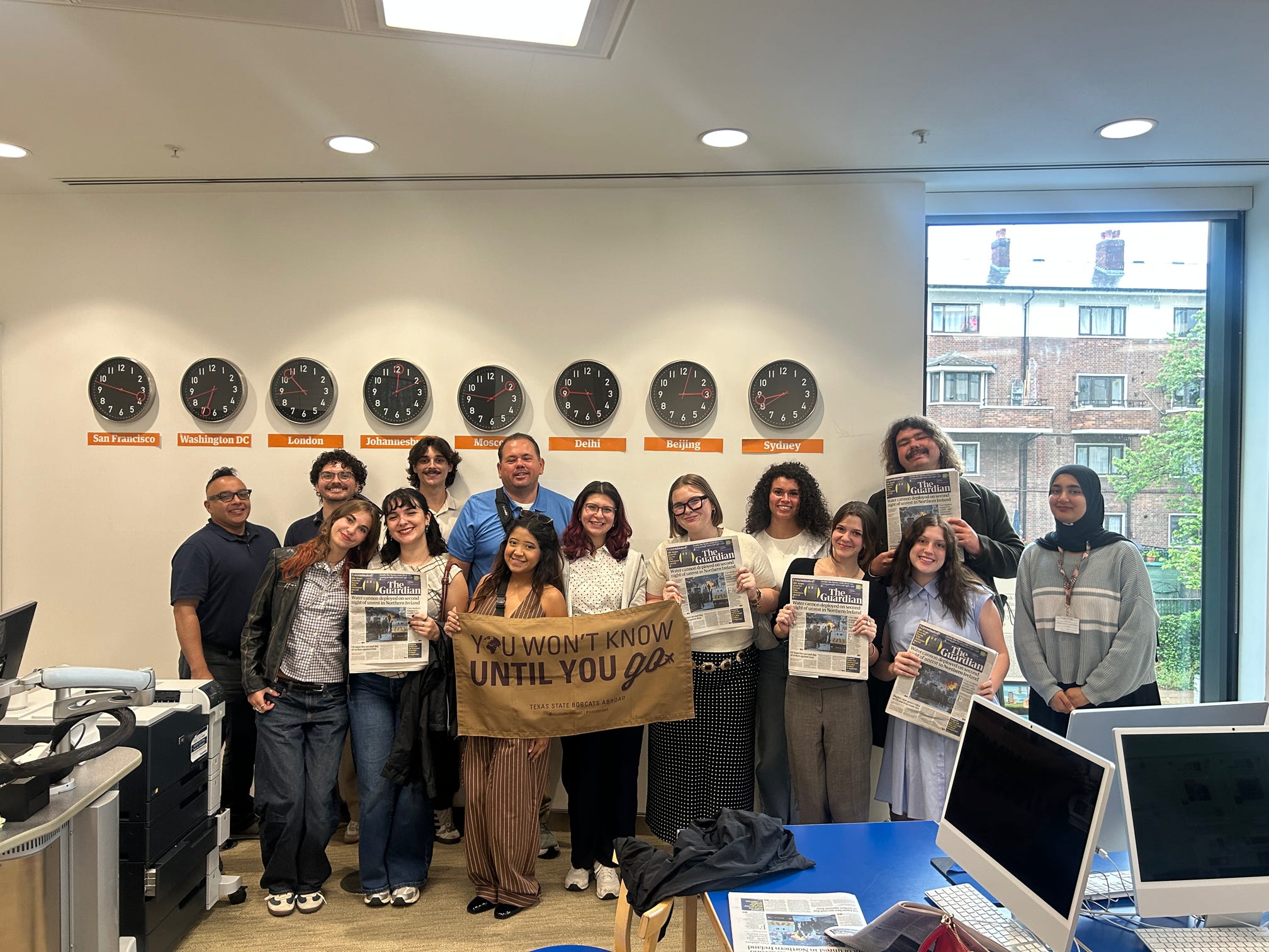a group of texas state students and staff members standing in the studios of The Guardian - London, United KIngdom 