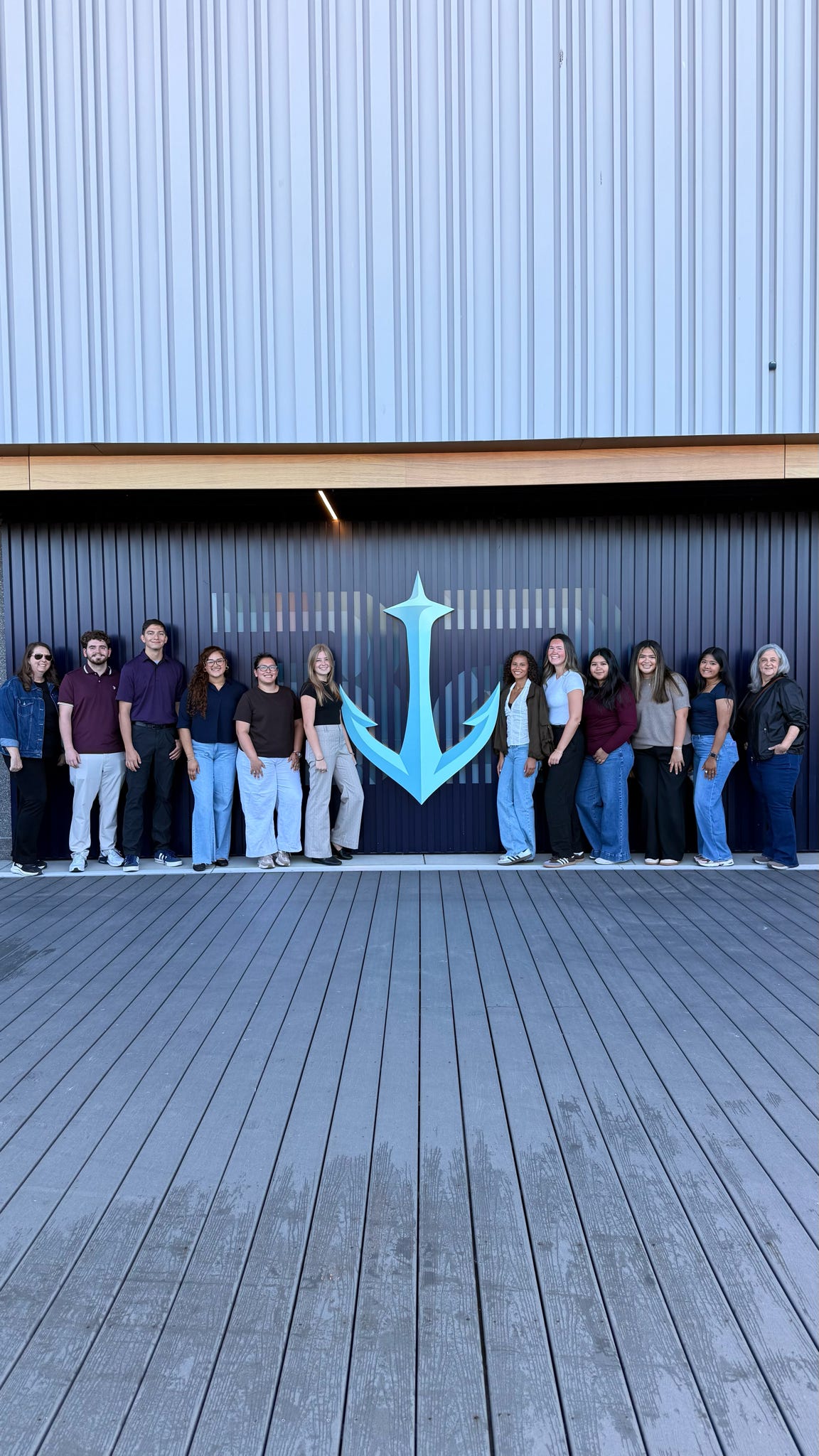A group of Texas State students and staff members posing with the Seattle Kraken Logo