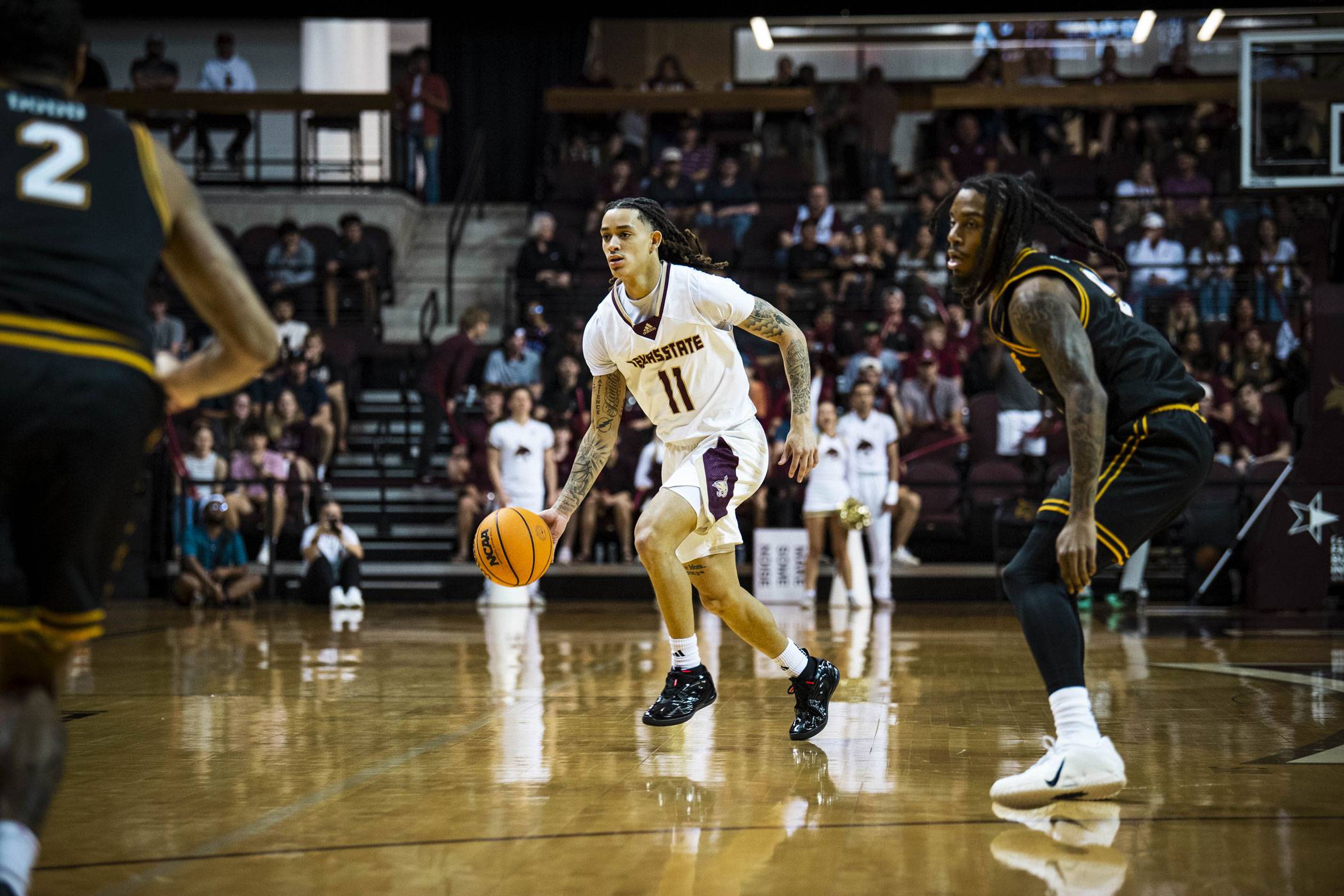 Bobcat basketball player drives down the court with the ball.