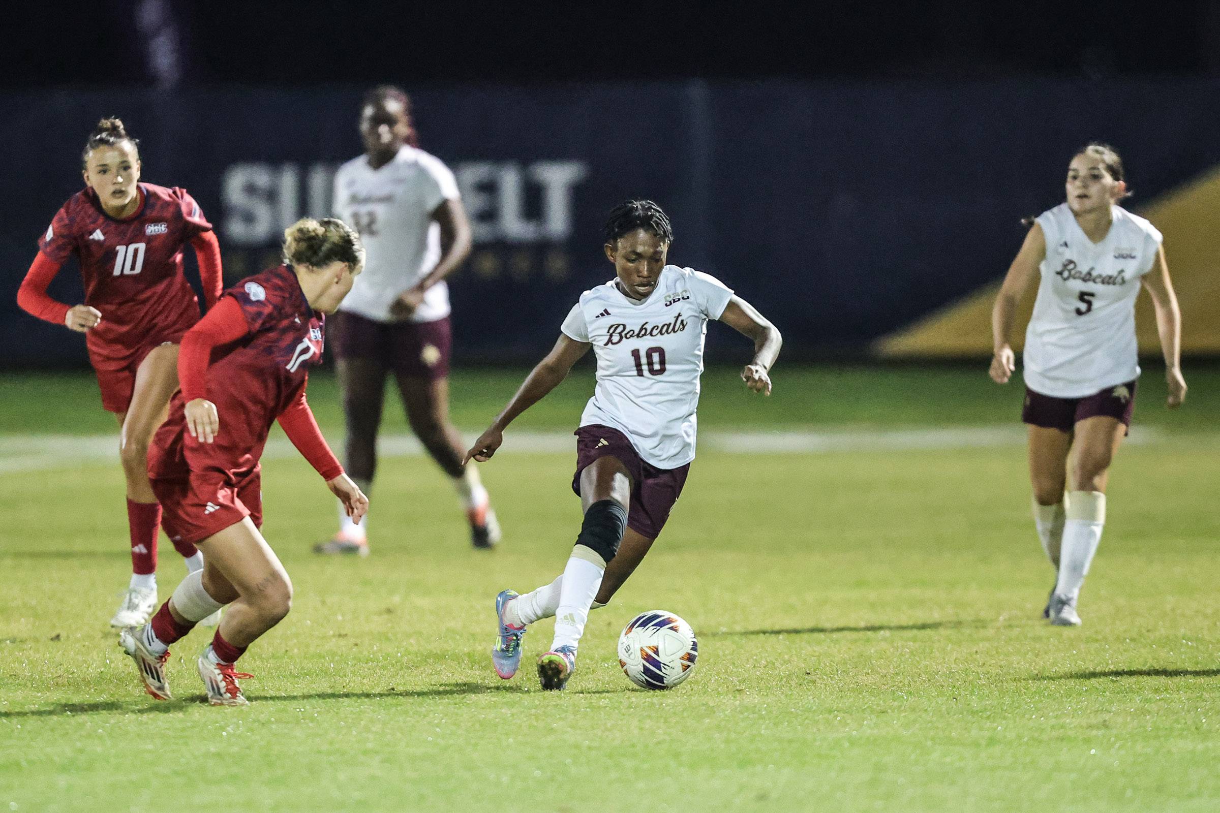 Helen Alormenu runs with the ball, evading several players from the opposing team.