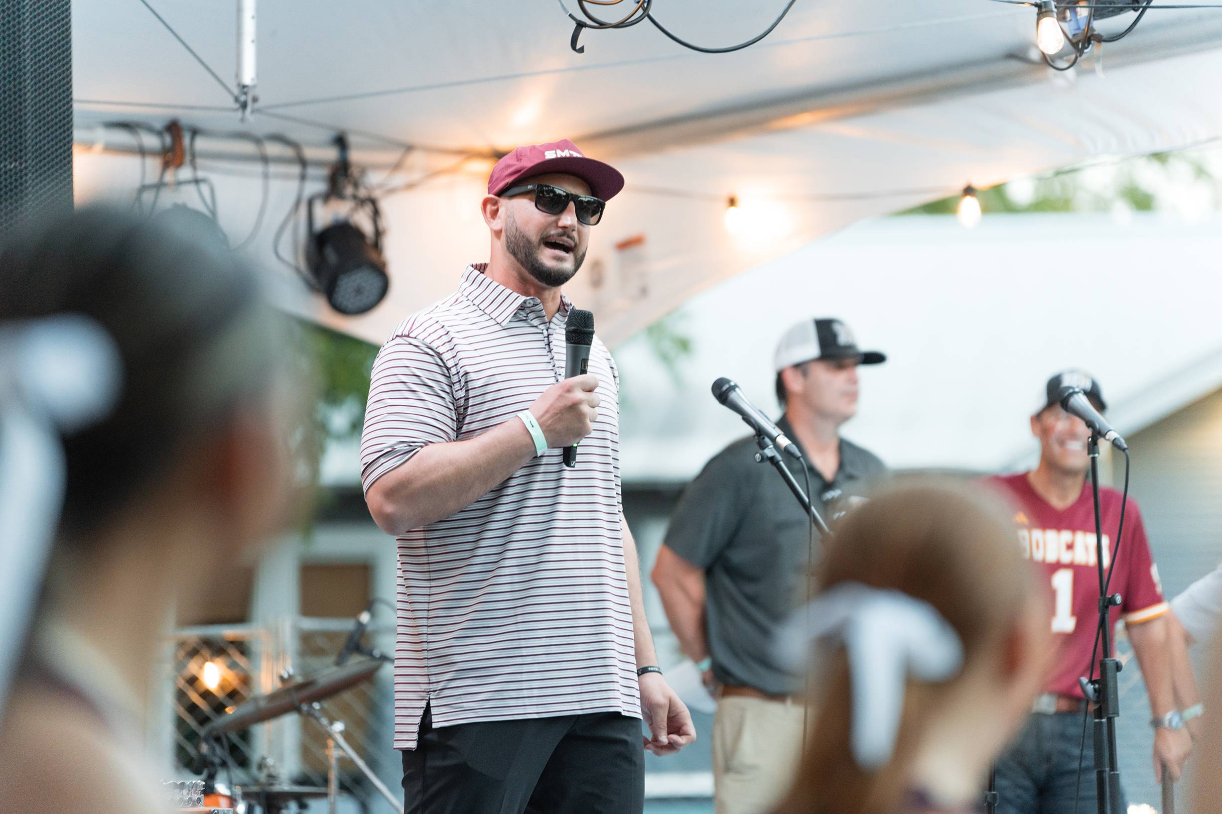 man on stage speaking into microphone