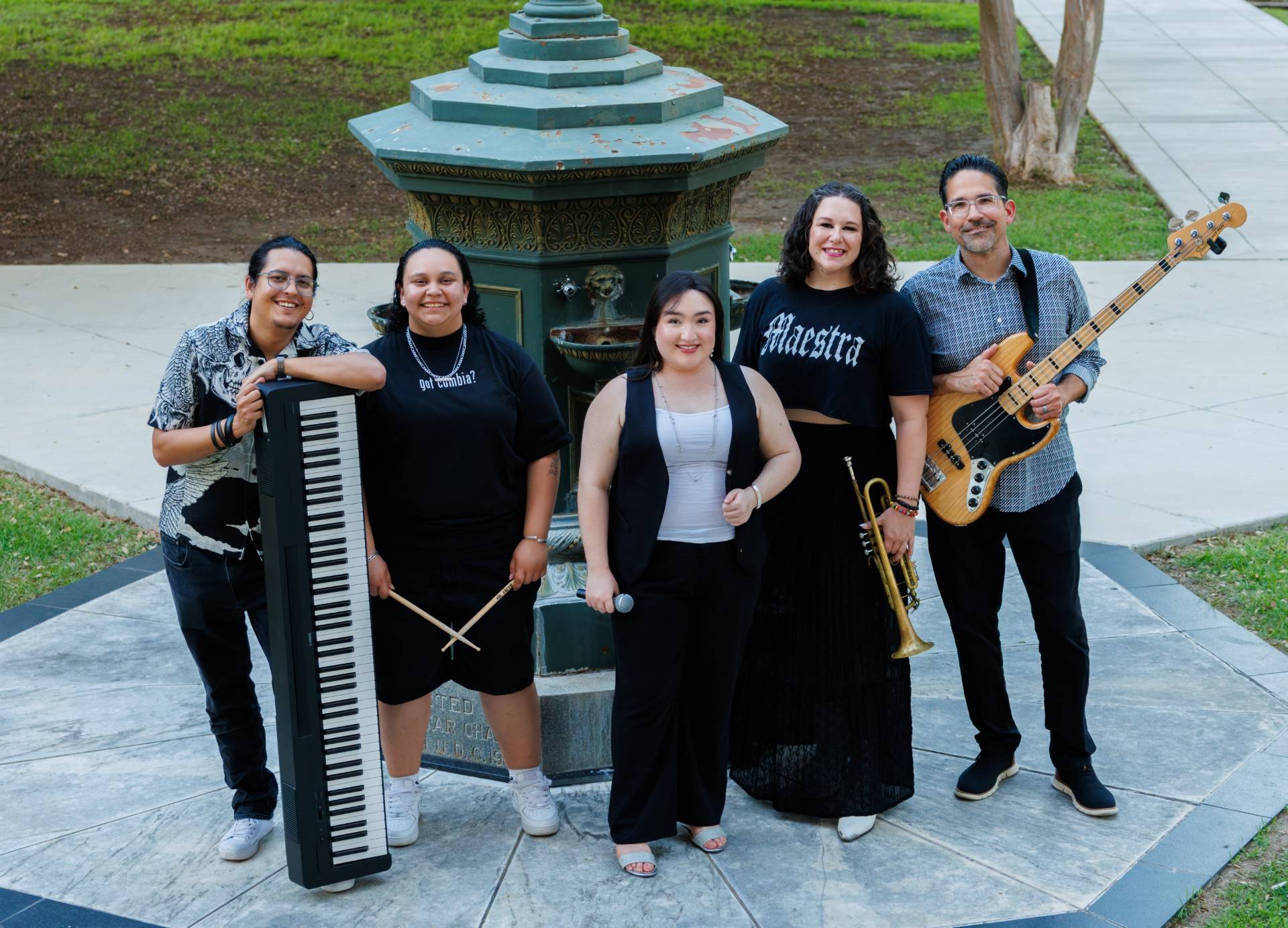 five band members pose for photo with instruments