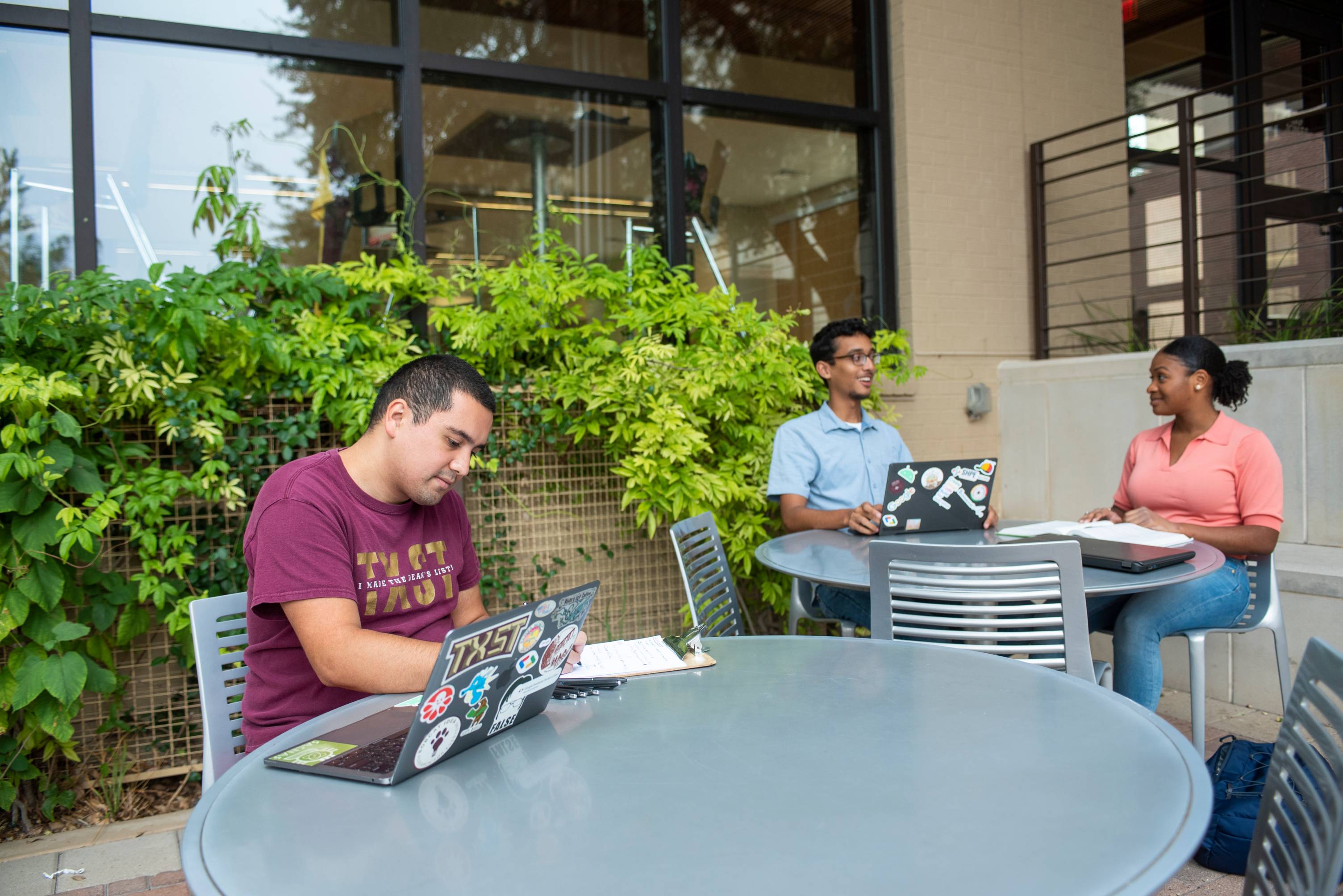 students sitting outside with laptops