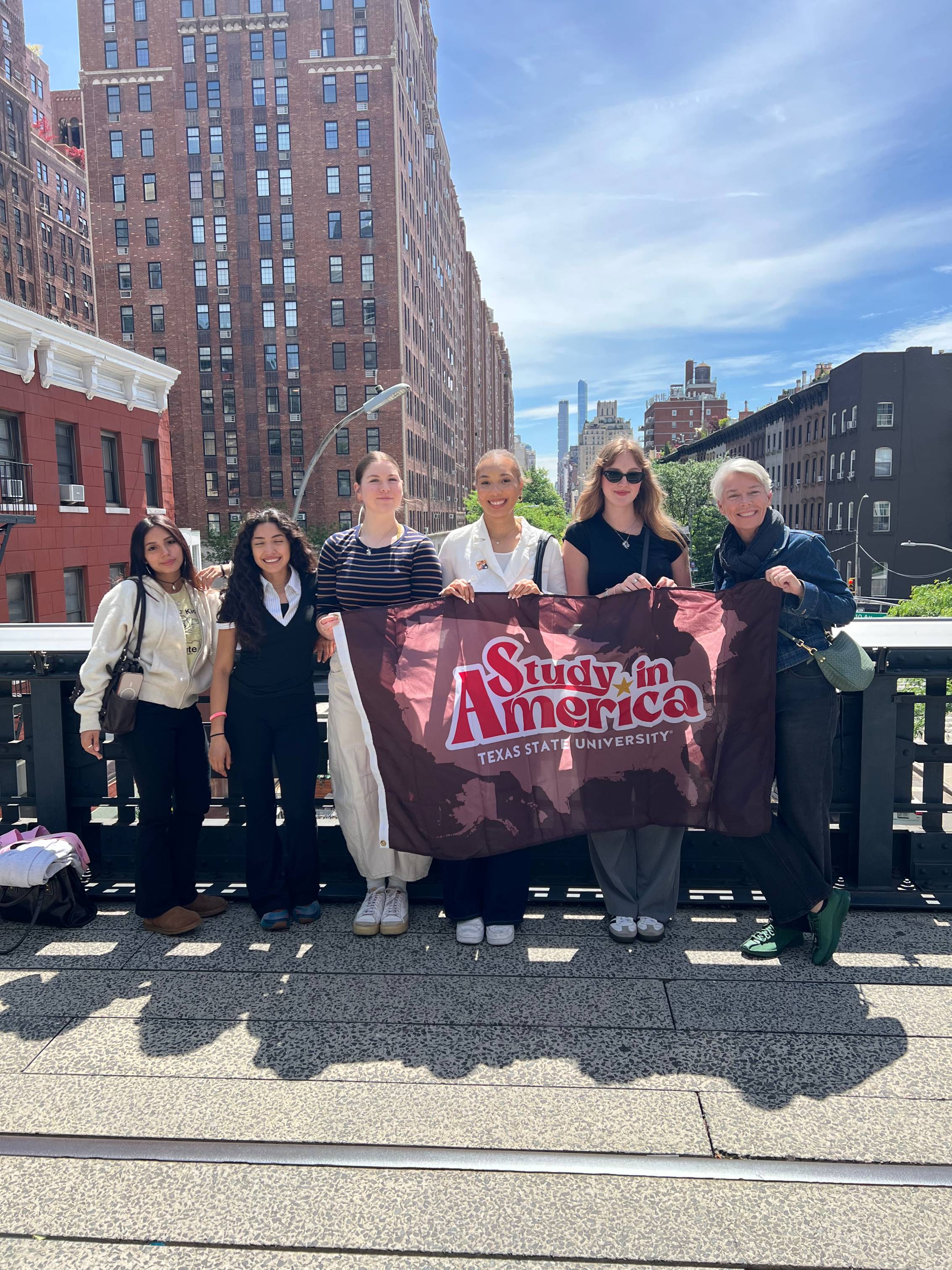 TXST students in NYC holding TXST flag