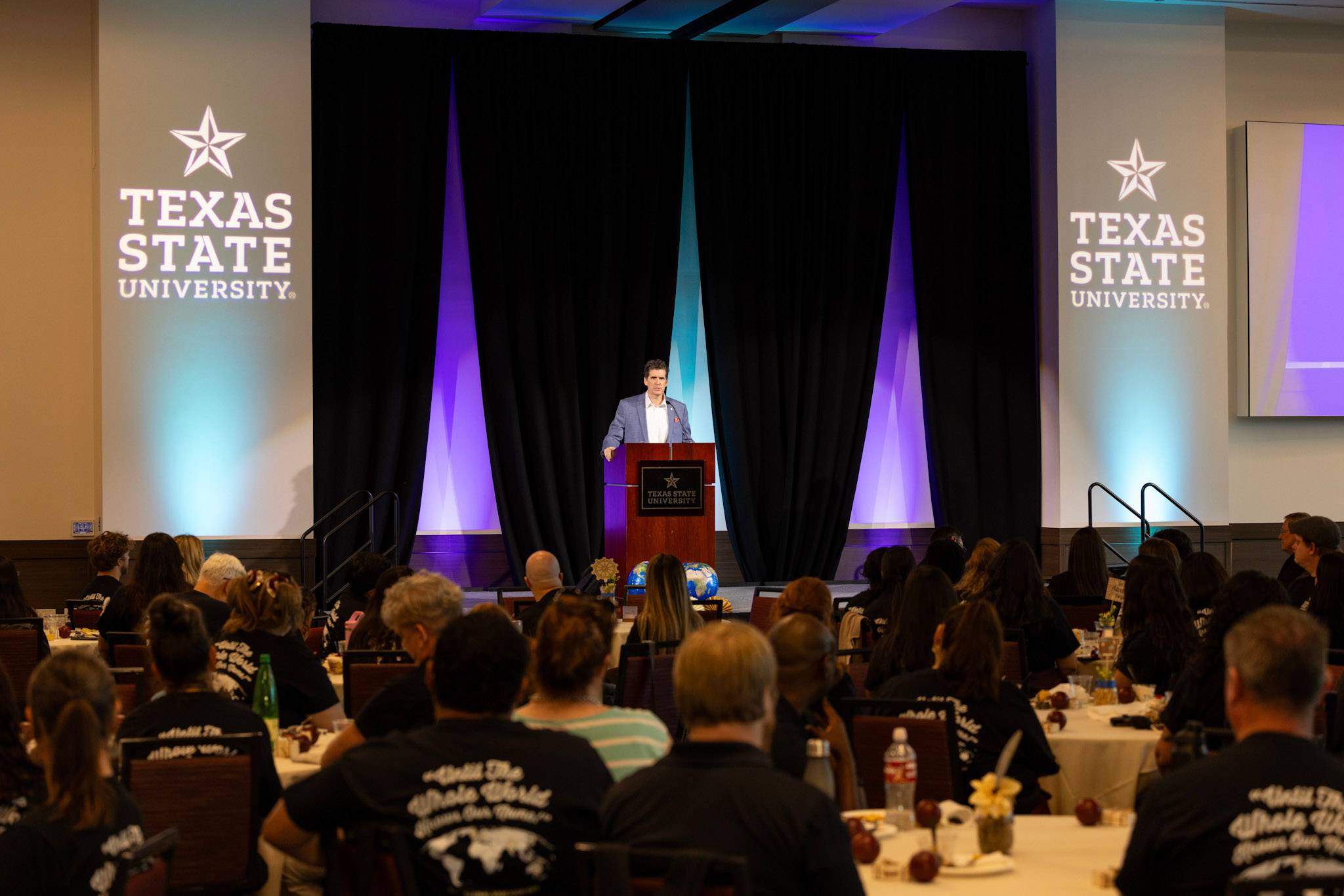 Christopher Murr speaking on stage at a Global Division event