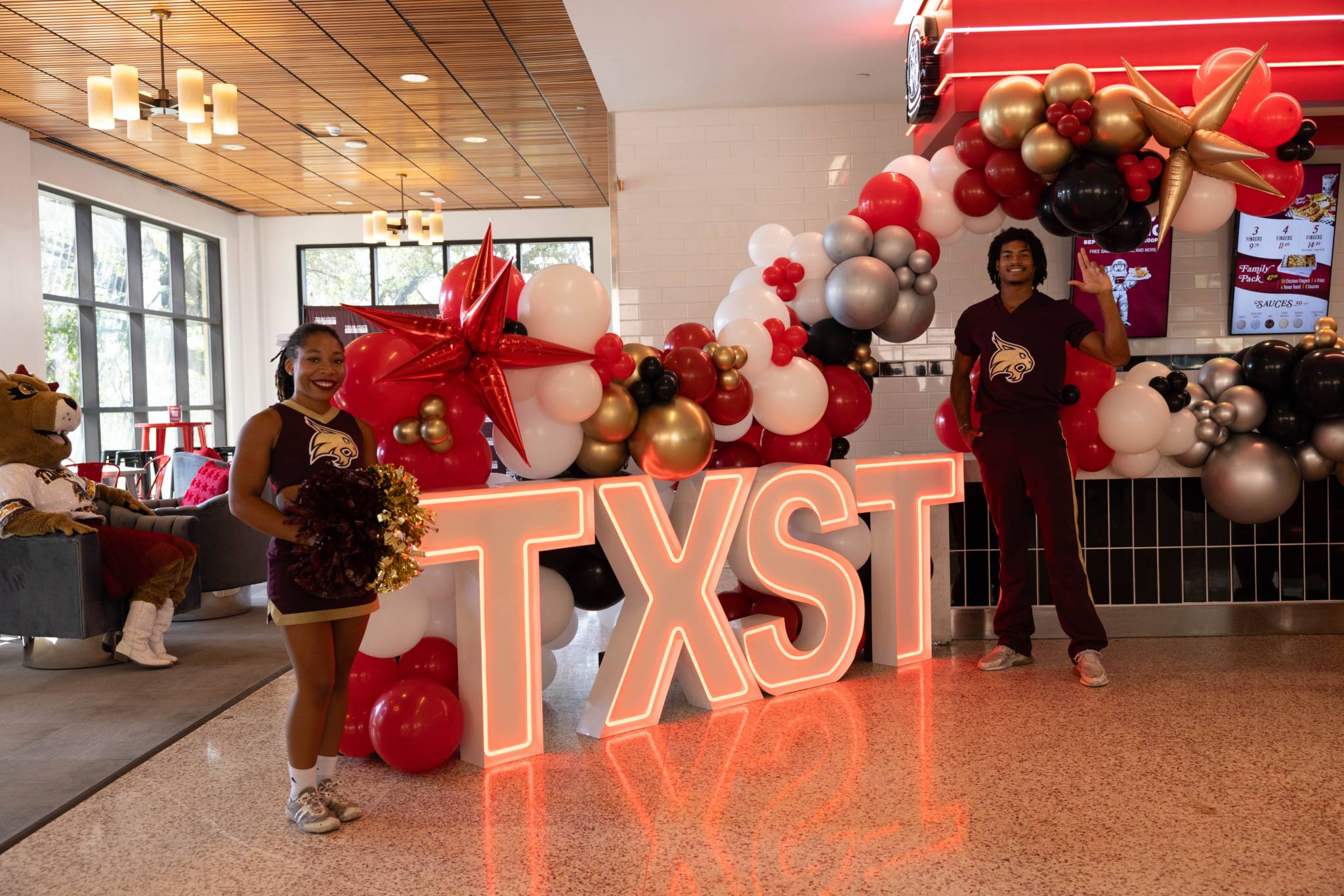 cheerleaders with TXST Sign